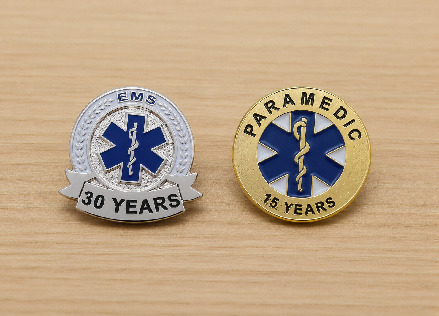 EMS service pins with the Star of Life symbol, one silver and one gold, commemorating 30 years of EMS and 15 years of paramedic service.