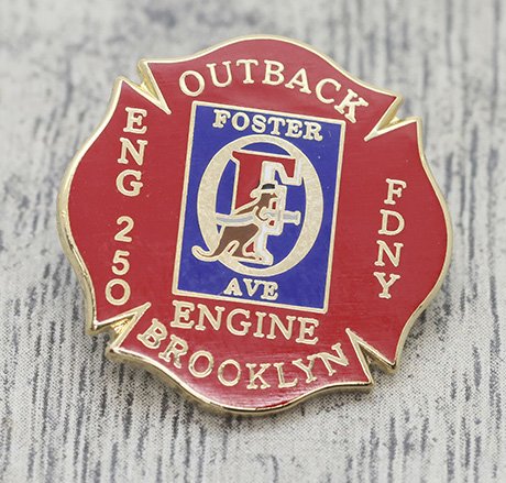 A firefighter service pin with the words 'Outback Engine 250 Brooklyn' and 'Foster Ave' on it.
