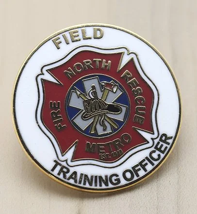 Service pin of the North Metro Fire Rescue Training Officer with a firefighter emblem at the center.