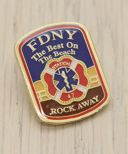 FDNY badge-shaped pin with the text 'FDNY The Best On The Beach' and 'Rock Away'.
