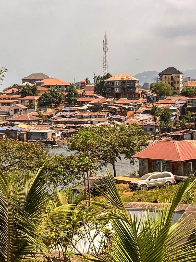 Udsigt over Freetown med byens huse og grønne bjerge i baggrunden.