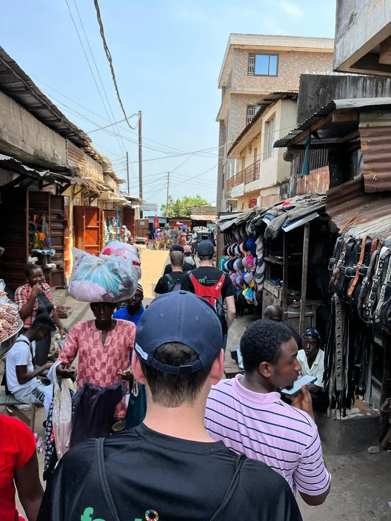 Gadeliv på et lokalt marked i Freetown, hvor danske gæster oplever hverdagslivet tæt på.