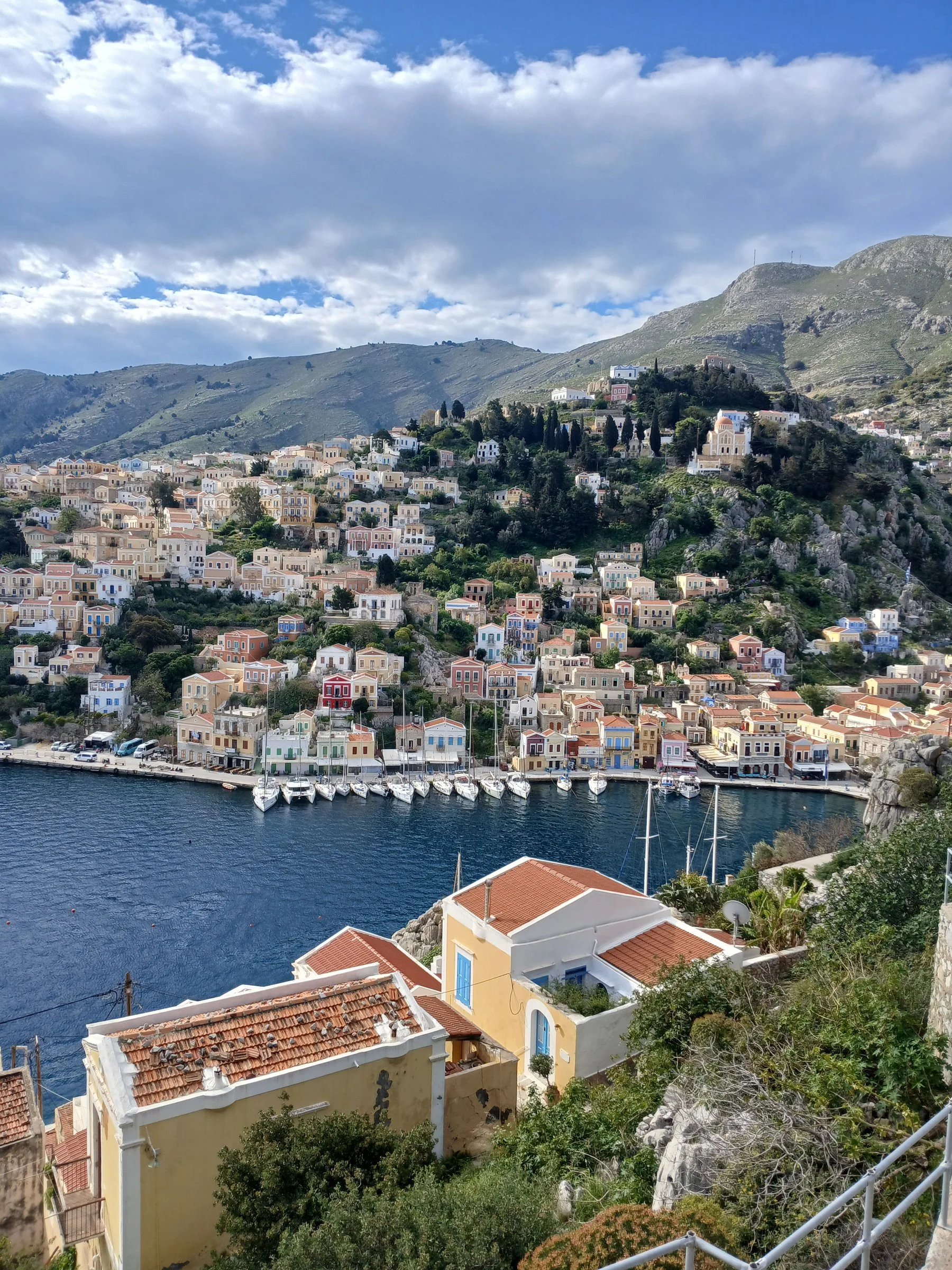 An amphitheater of pastel colors, carved into the Aegean hills.