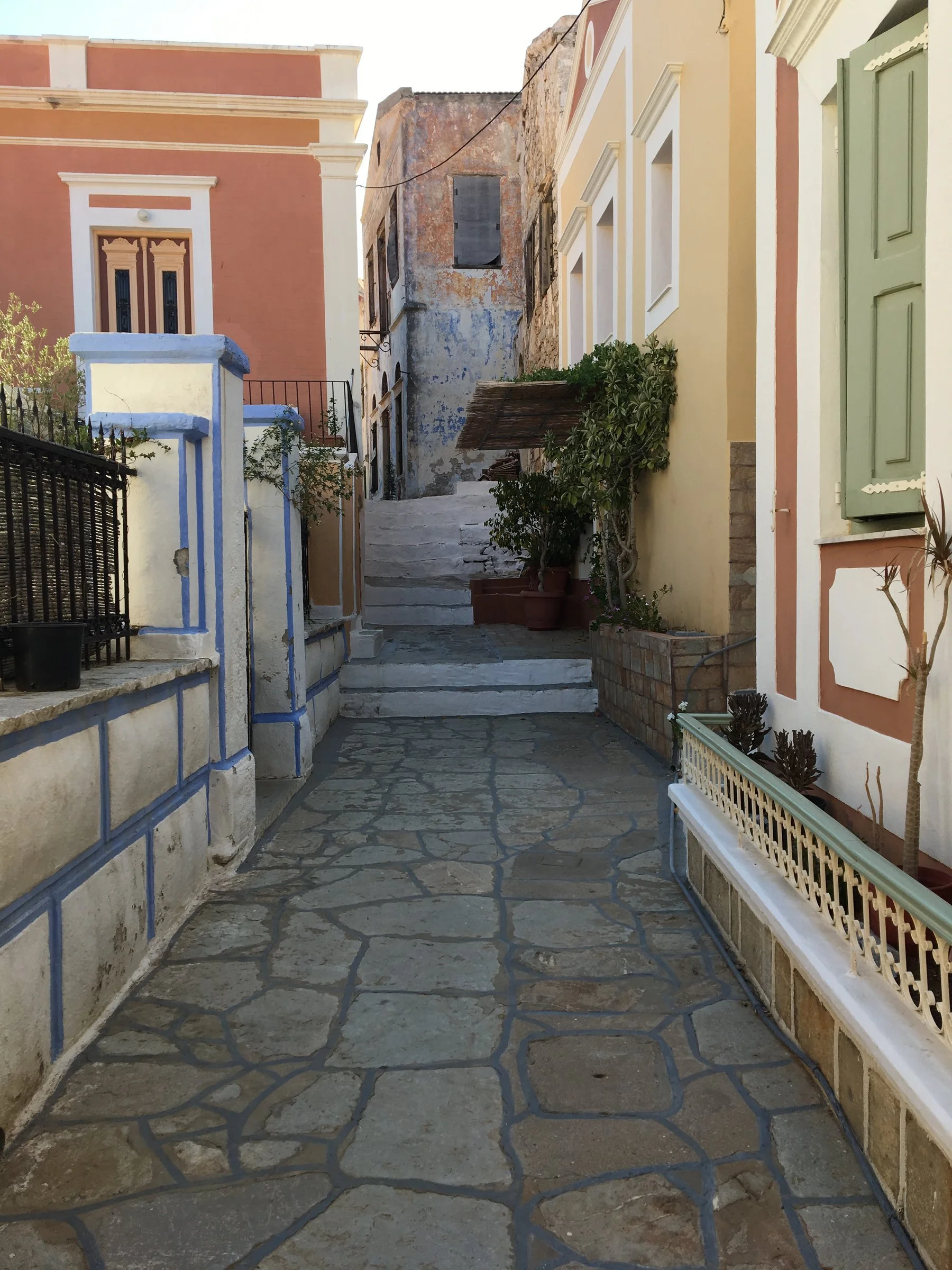 Stone pathways, whispering the stories of our childhood, framed by the quiet geometry of neoclassical mansions.