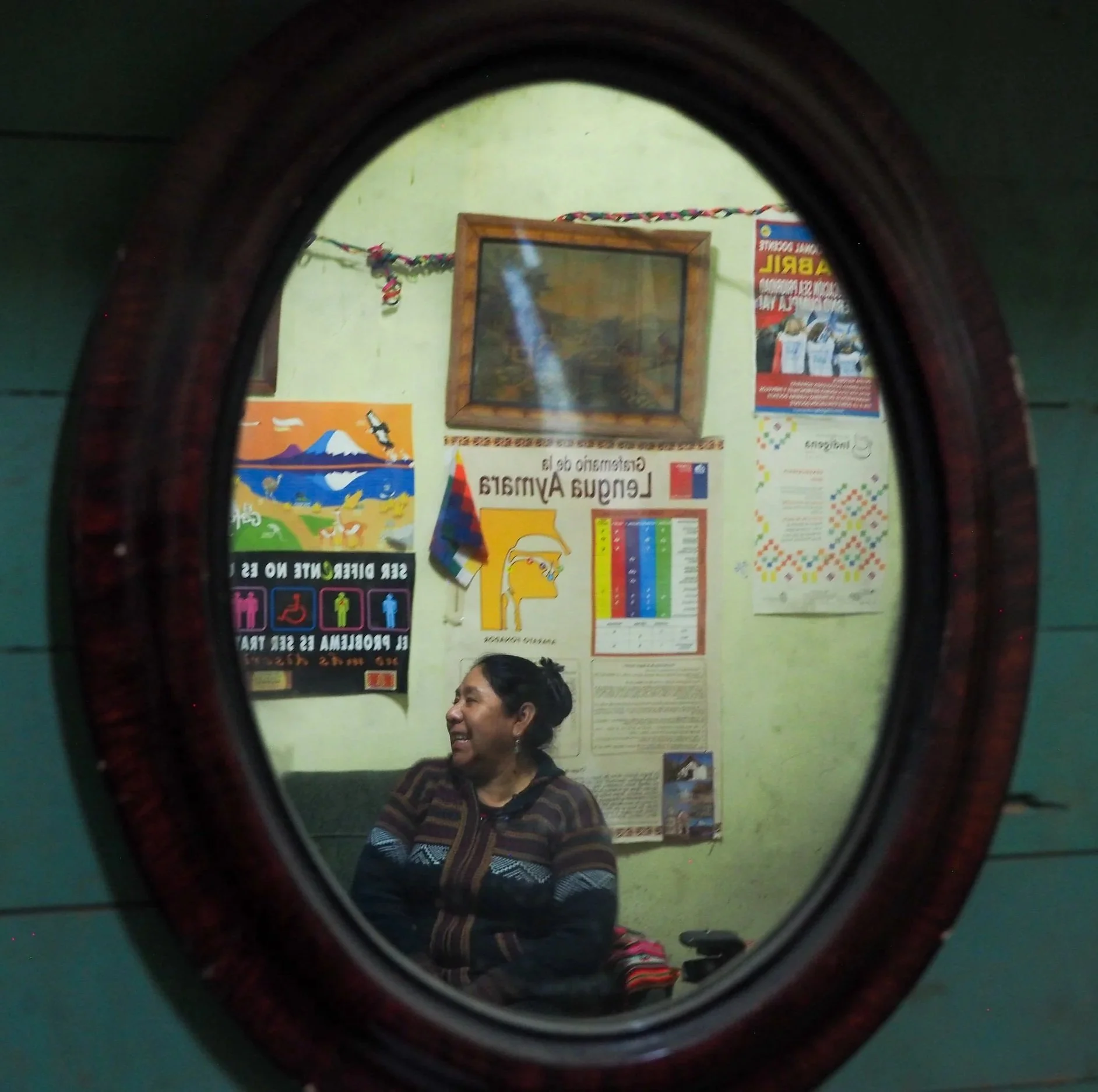 Mujer sonriendo vista a través de un espejo redondo