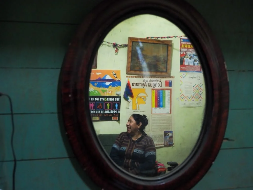 Mujer sonriendo vista a través de un espejo redondo