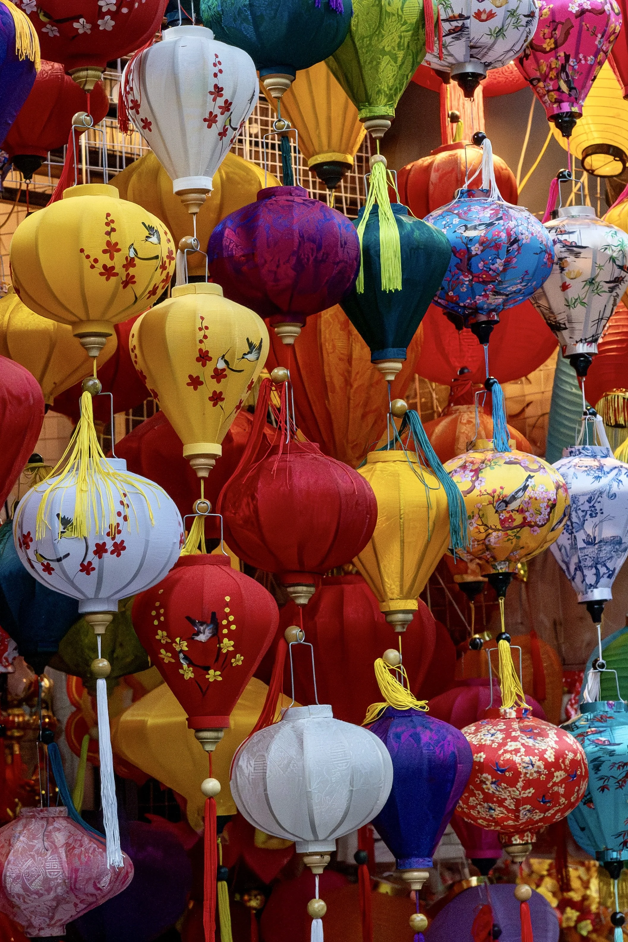 Dense cluster of colorful silk lanterns hanging in a market street