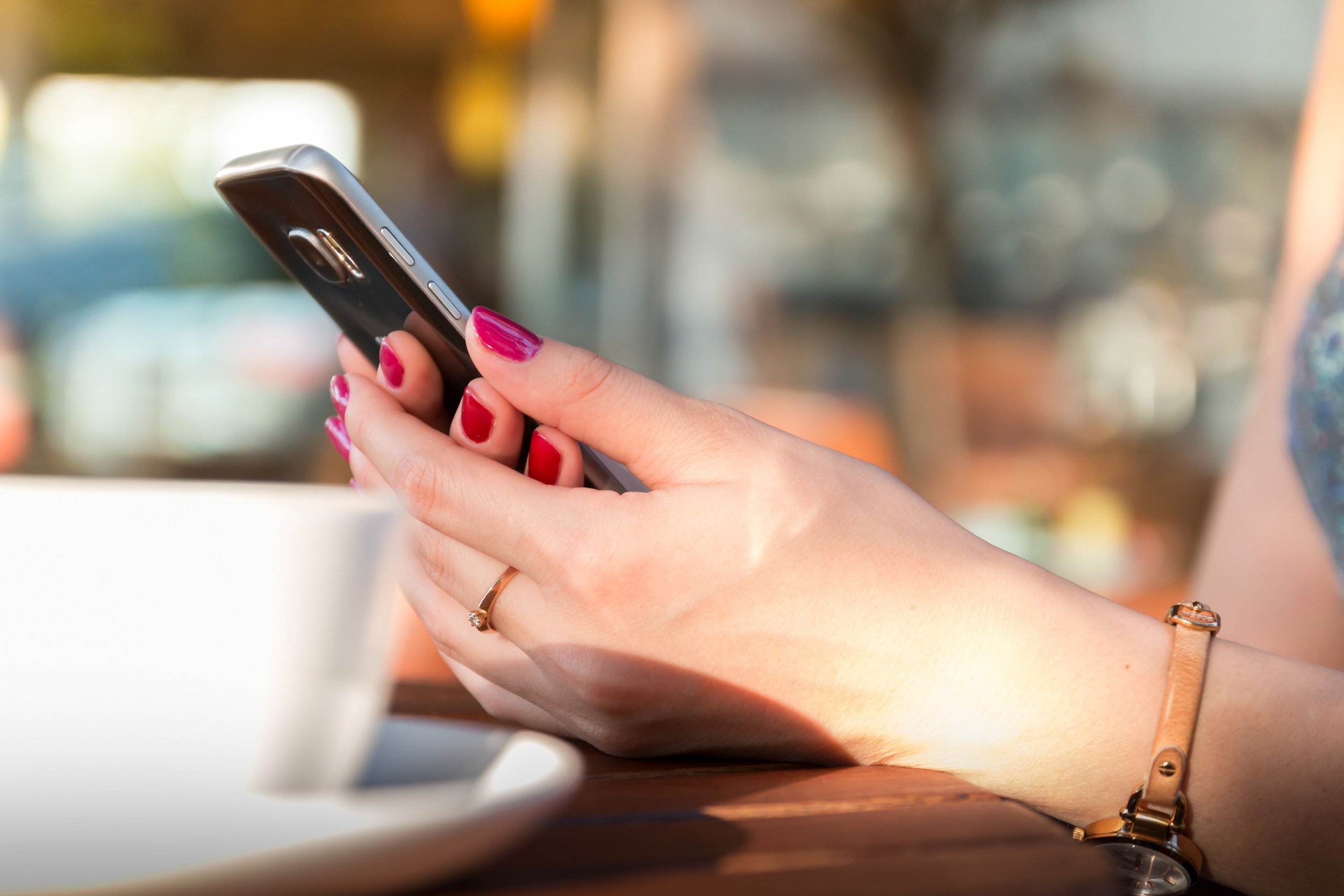 Hands holding a smartphone, representing following The Real Life Reboot on social media