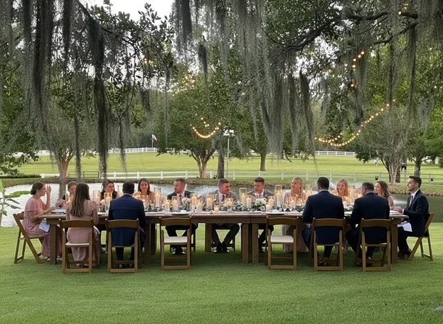 Outdoor rehearsal dinner celebration at Five Oaks Farm event venue in Alachua, florida, with guests seated at a long table beneath the oak trees