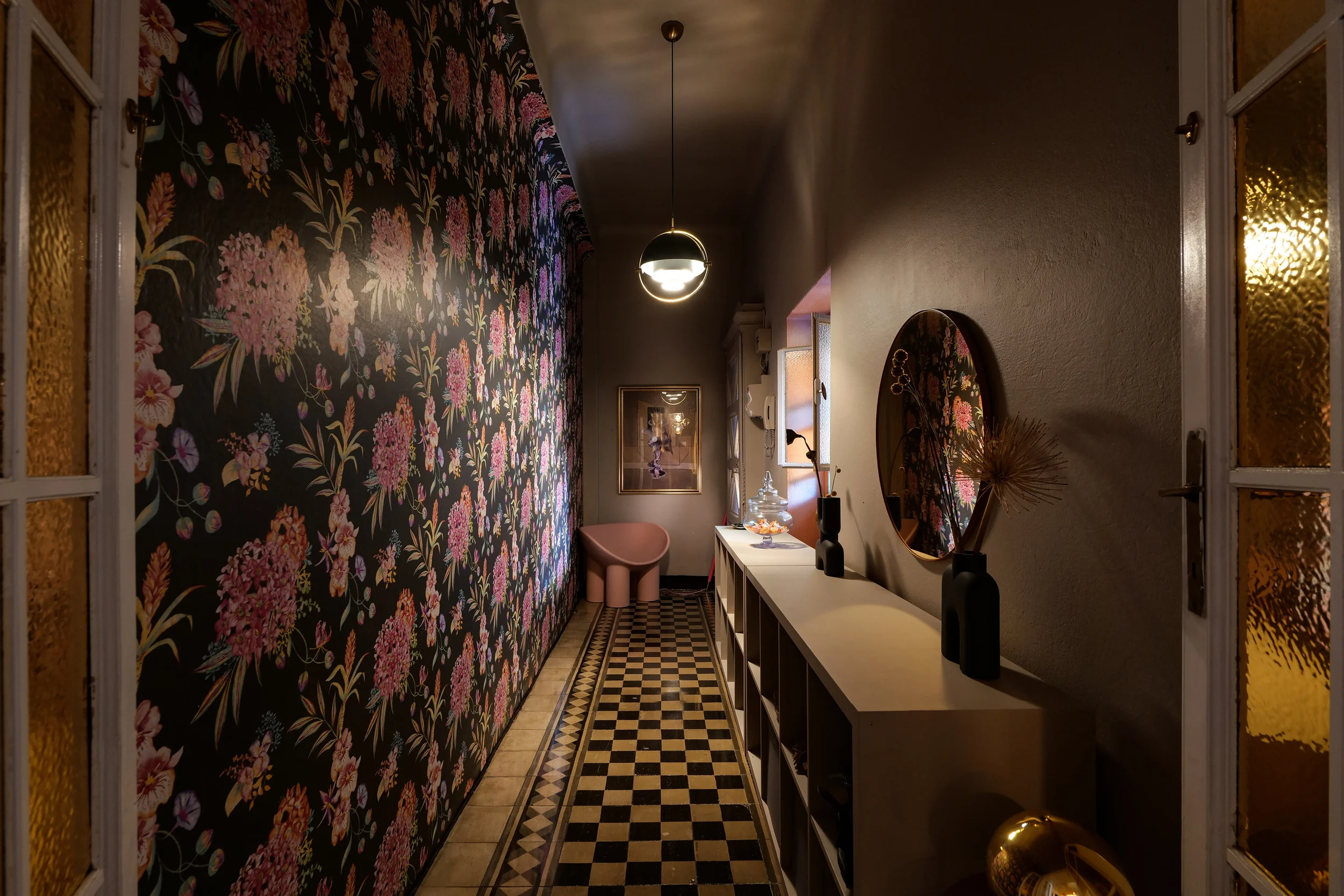 Dark floral-wallpaper corridor, checkerboard floor, Gubi Multi-Lite pendant and pink Roly-Poly chair — House of Frames, Milan
