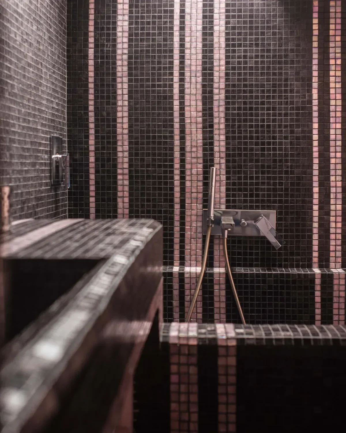 Striped black and pink Bisazza mosaic with Fantini mixer taps and hand shower