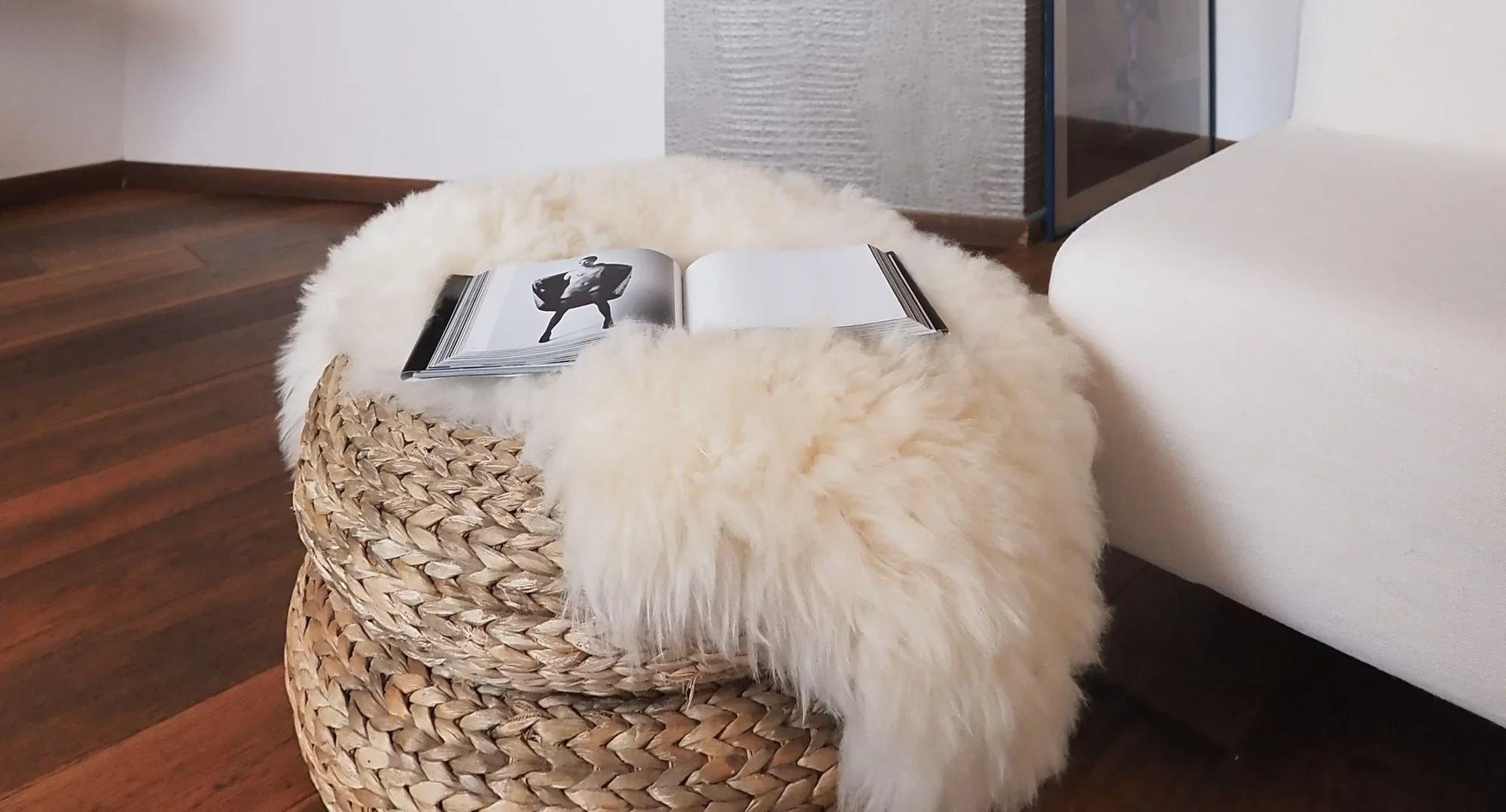 Mapplethorpe photography book open on the sheepskin over the woven pouf
