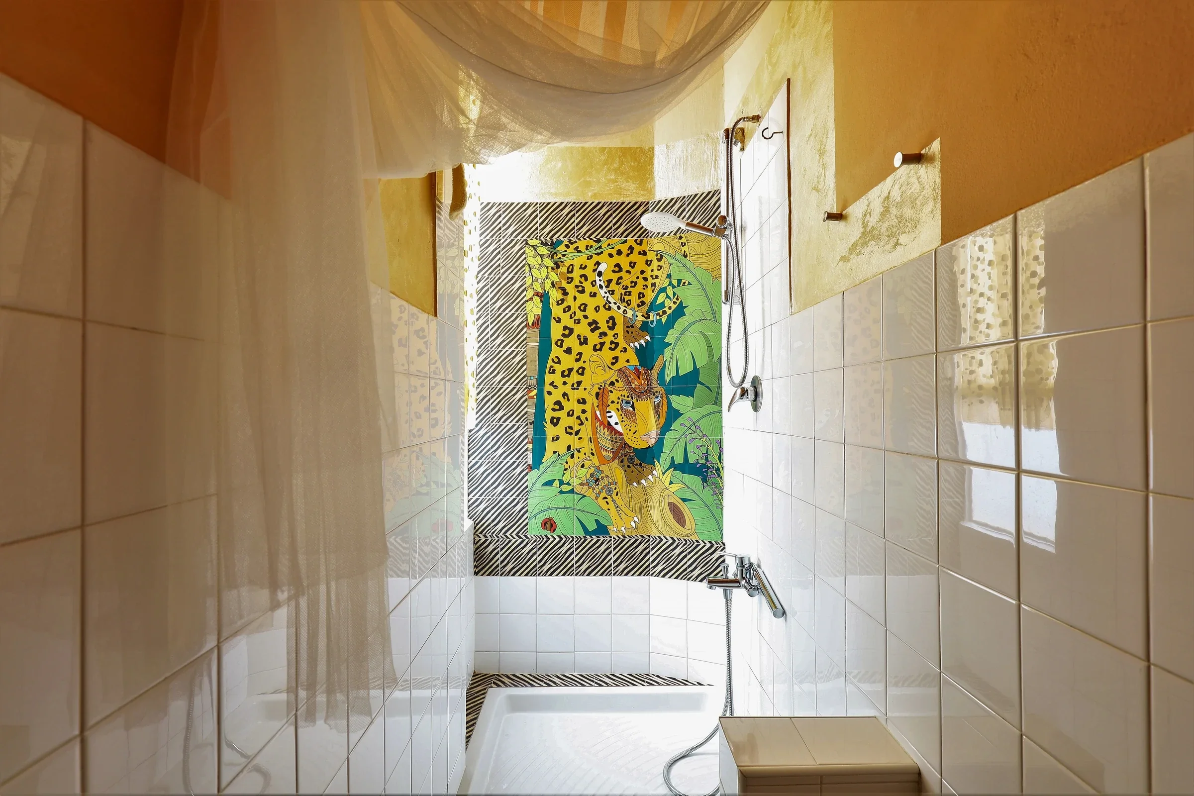 Leopard artwork in the tiled shower under the mosquito net
