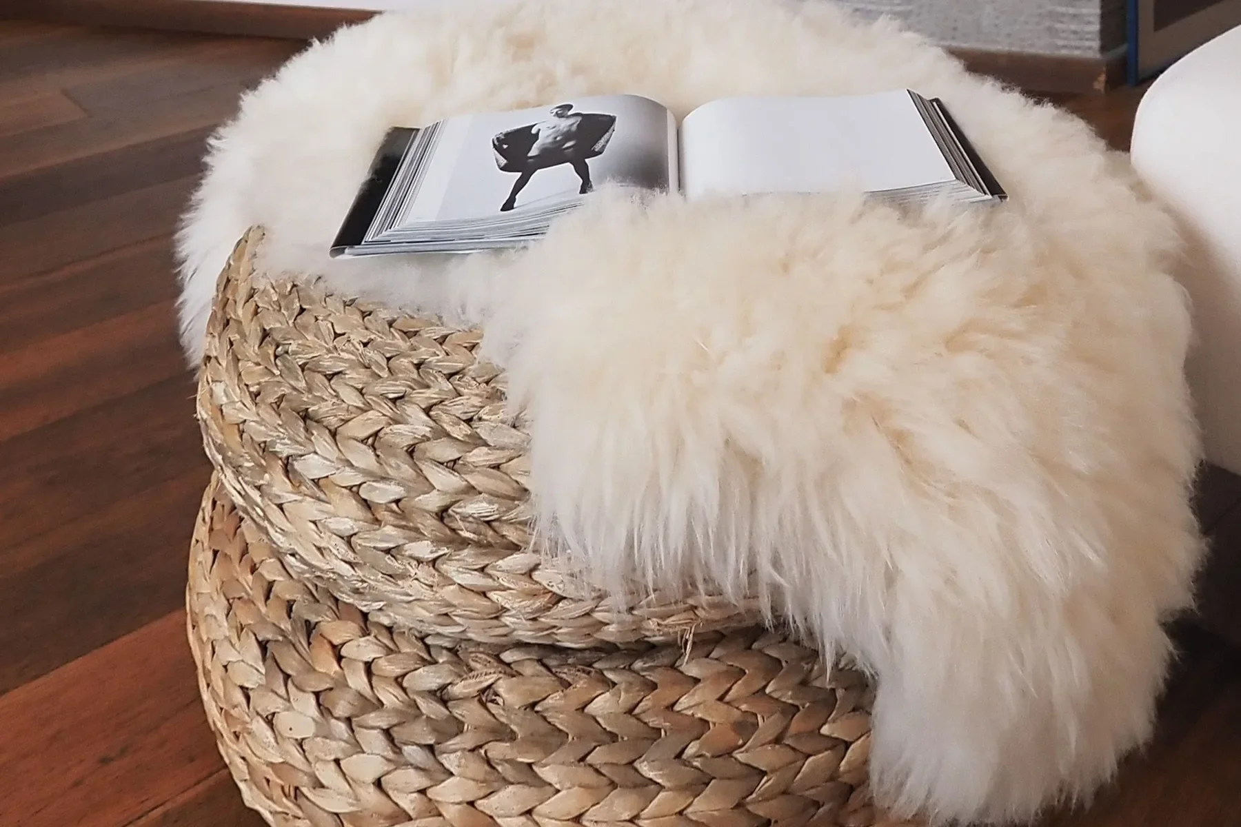 Reading corner: a Mapplethorpe photography book open on the sheepskin over the wicker pouf, Via Paolo Sarpi, Milano