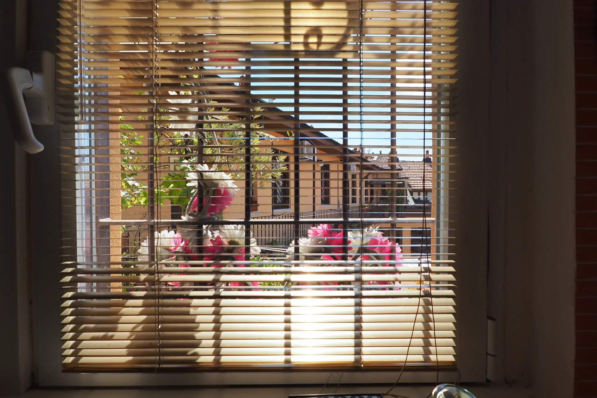 Kitchen window with venetian blinds over the Milanese rooftops