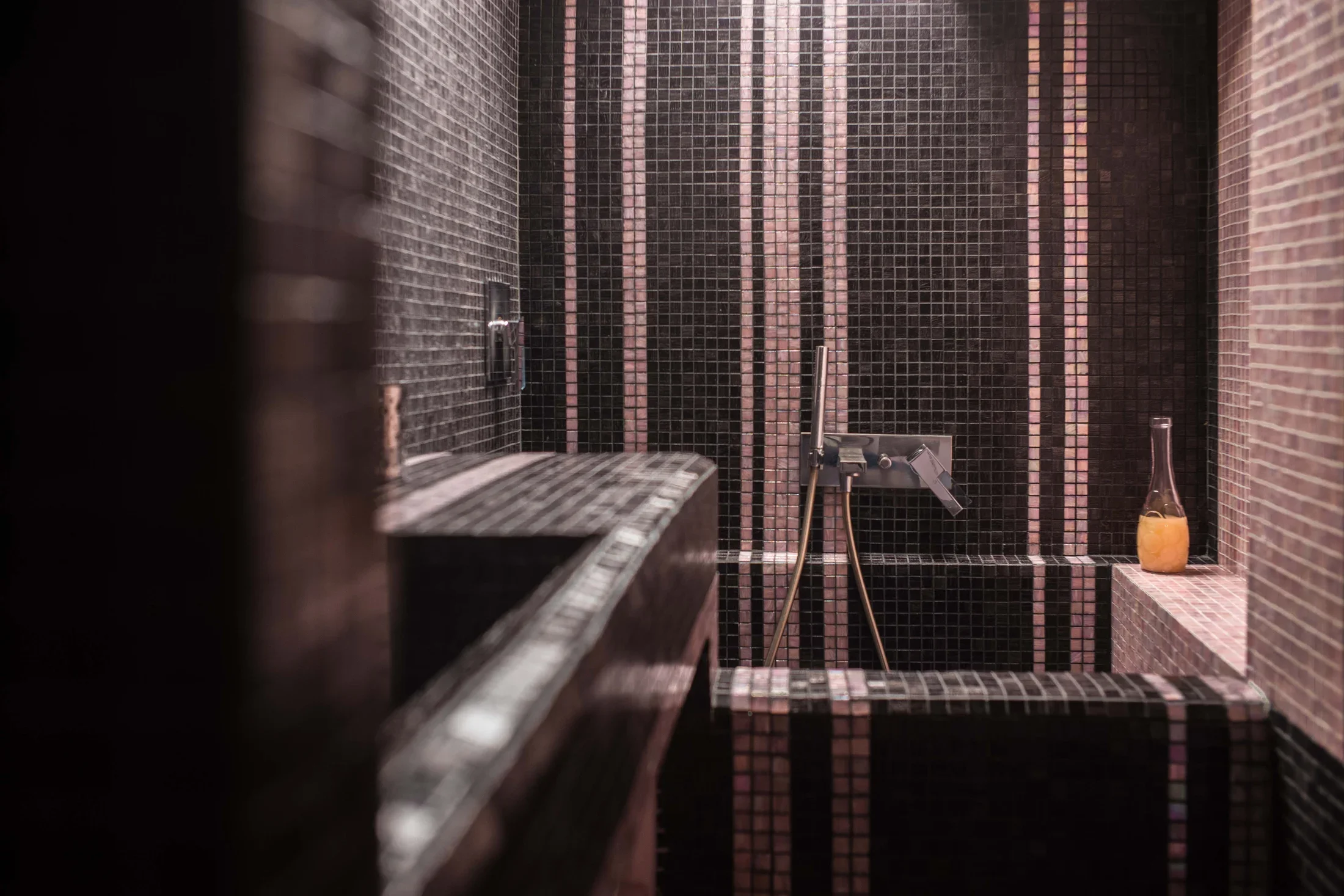 Black Bisazza mosaic bathroom with Fantini wall-mounted mixer taps over the tiled basin, Milano