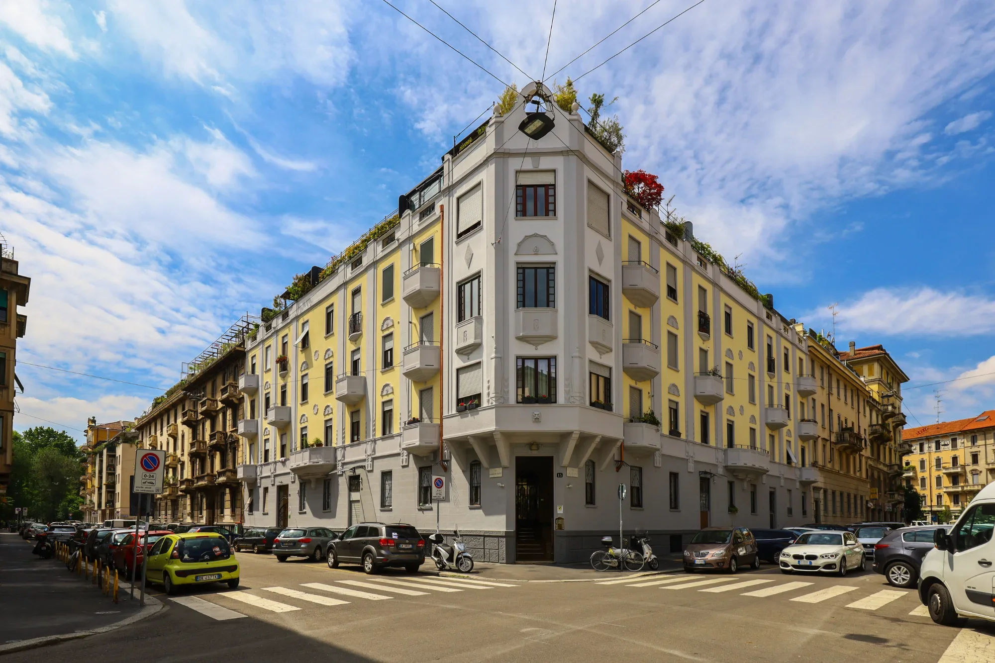 Art Déco corner-palazzo façade under the Milan sky — House of Frames, boutique B&B Milan