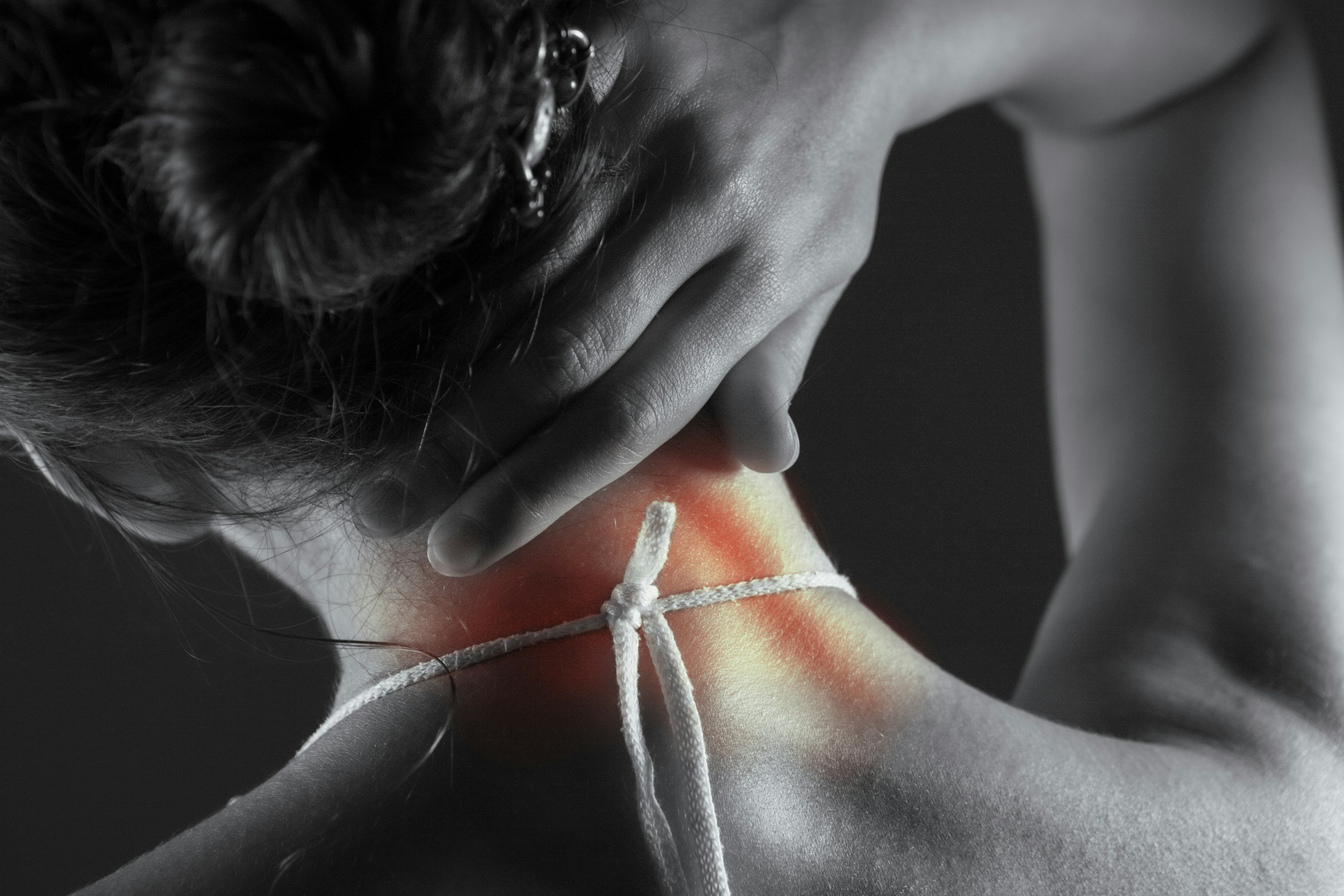 a person touching their neck, indicating soreness