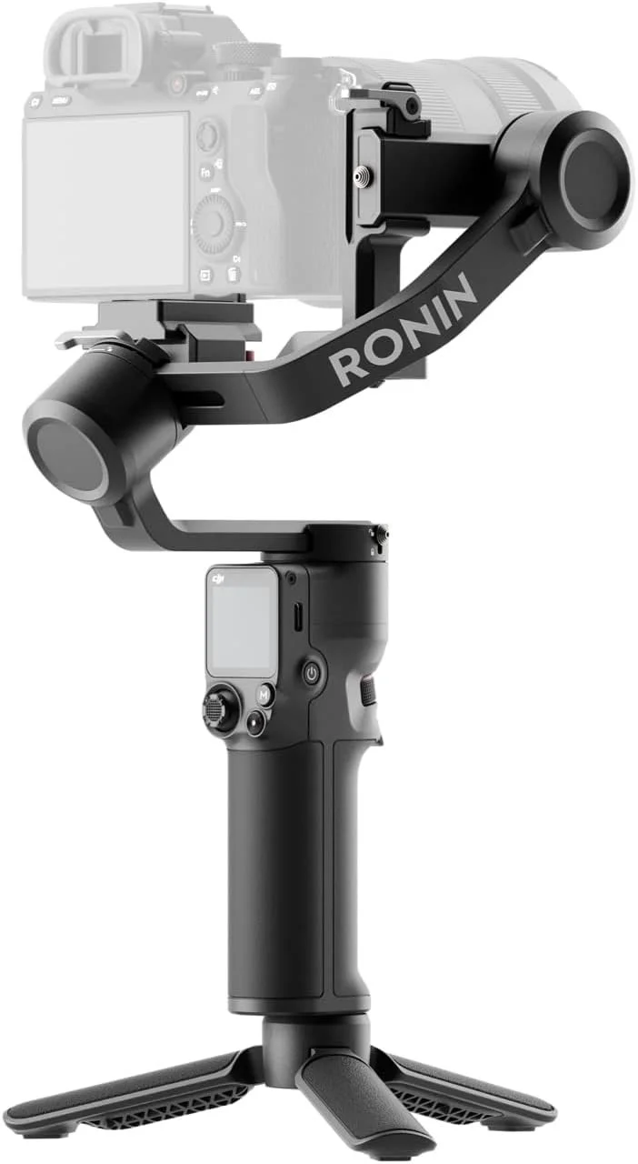 Gimbal stabilisateur professionnel Noir avec la marque Ronin, monté sur un stabilisateur à main avec un écran intégré, tenu par une main, avec une caméra montée dessus.