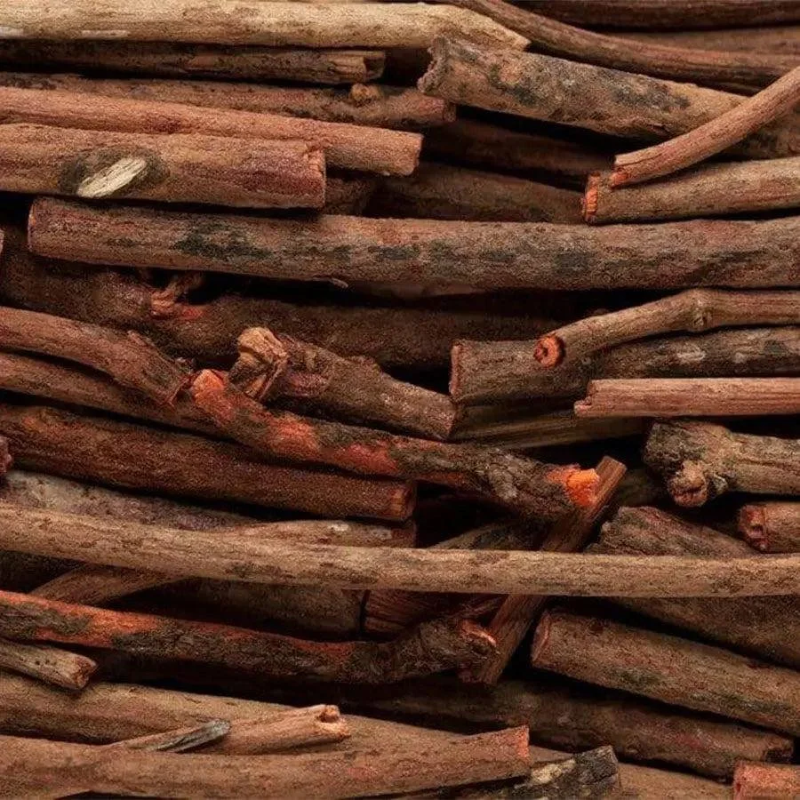 A pile of stacked firewood logs with rough, textured surfaces and reddish-brown tones.