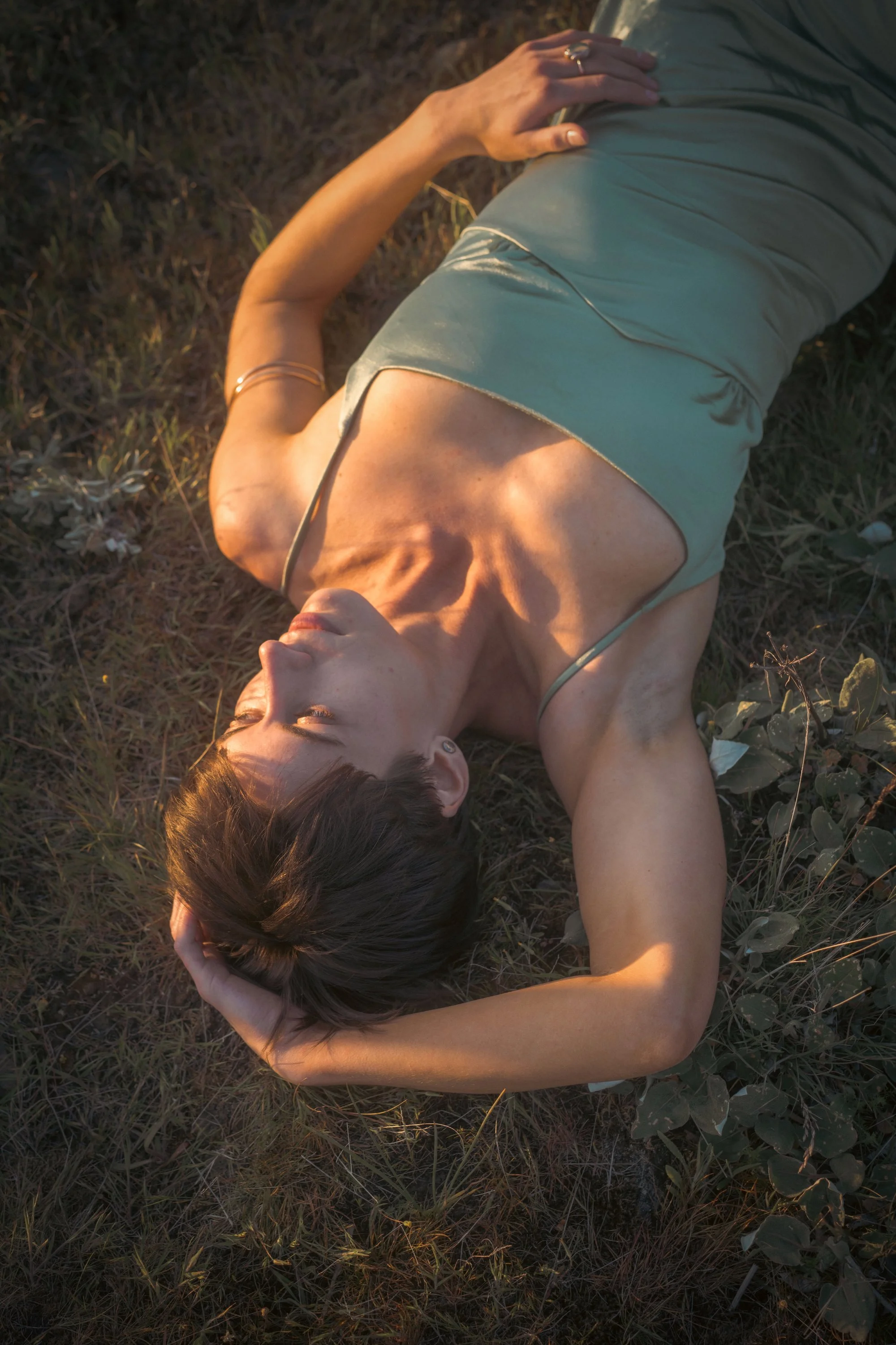 Woman lying in golden hour light in a field, portrait photography by Missoula Montana photographer