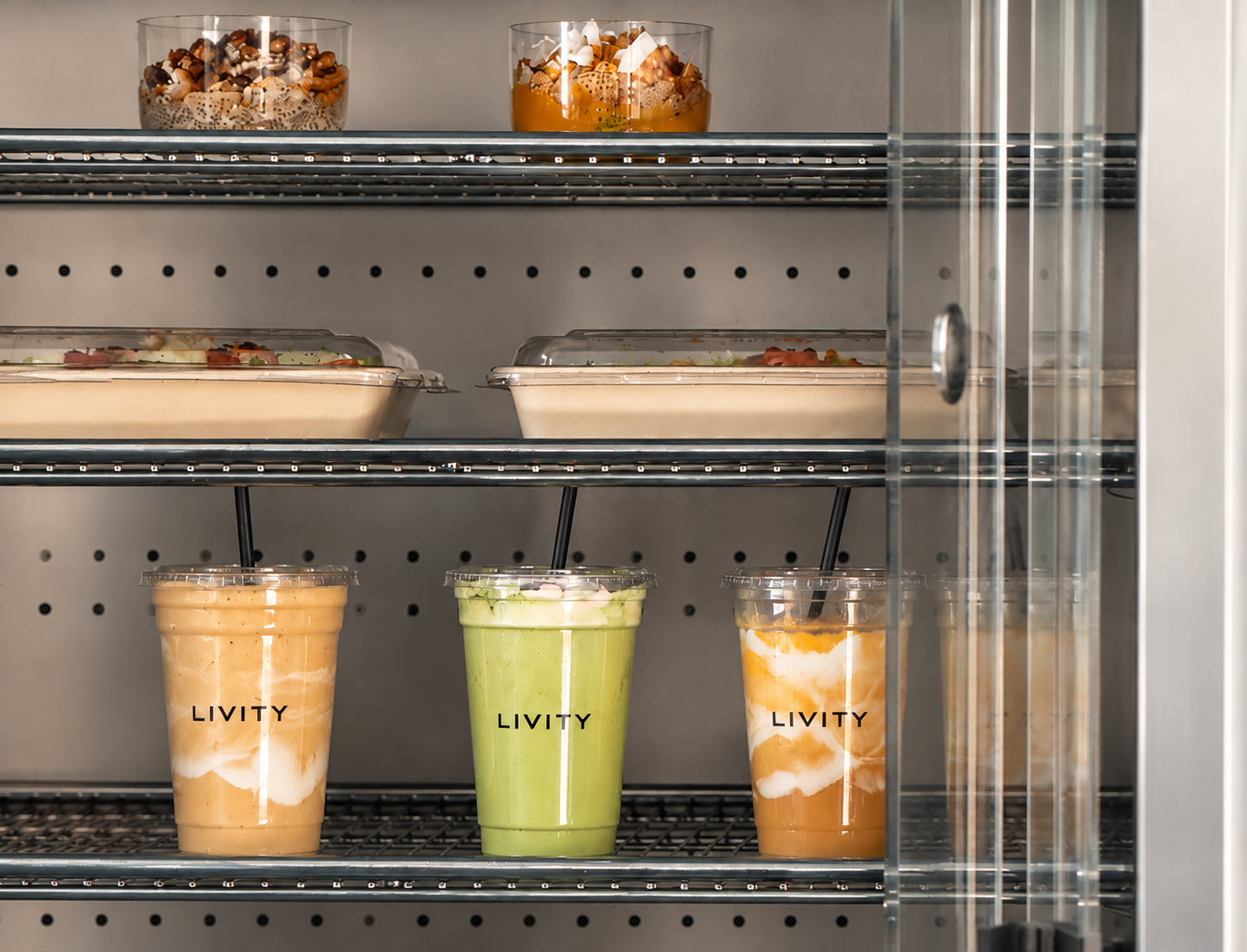 Livity smoothies in branded clear cups displayed in the grab-and-go fridge with prepared food above.