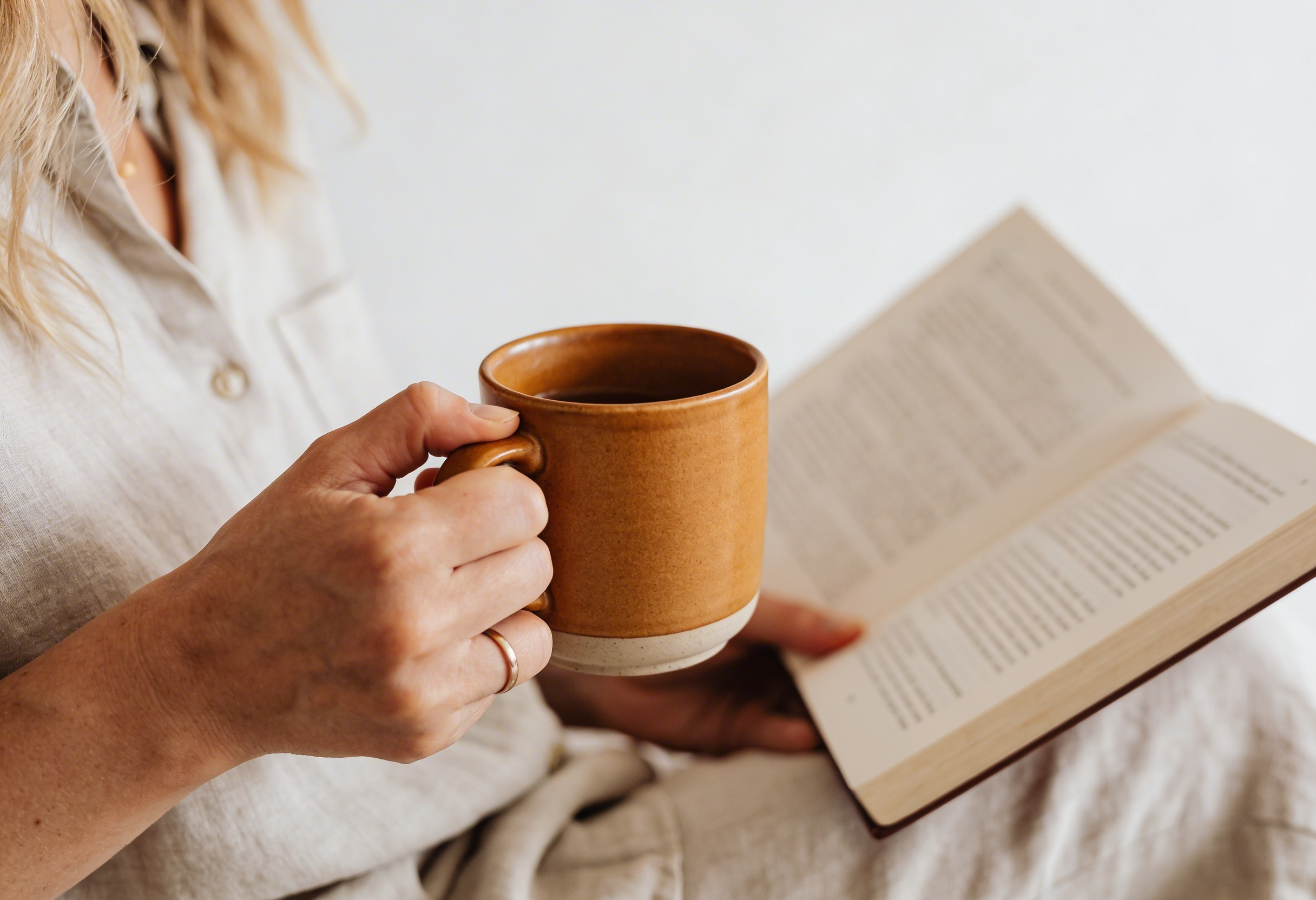 Woman relaxing with tea and a book — calm support through pregnancy
