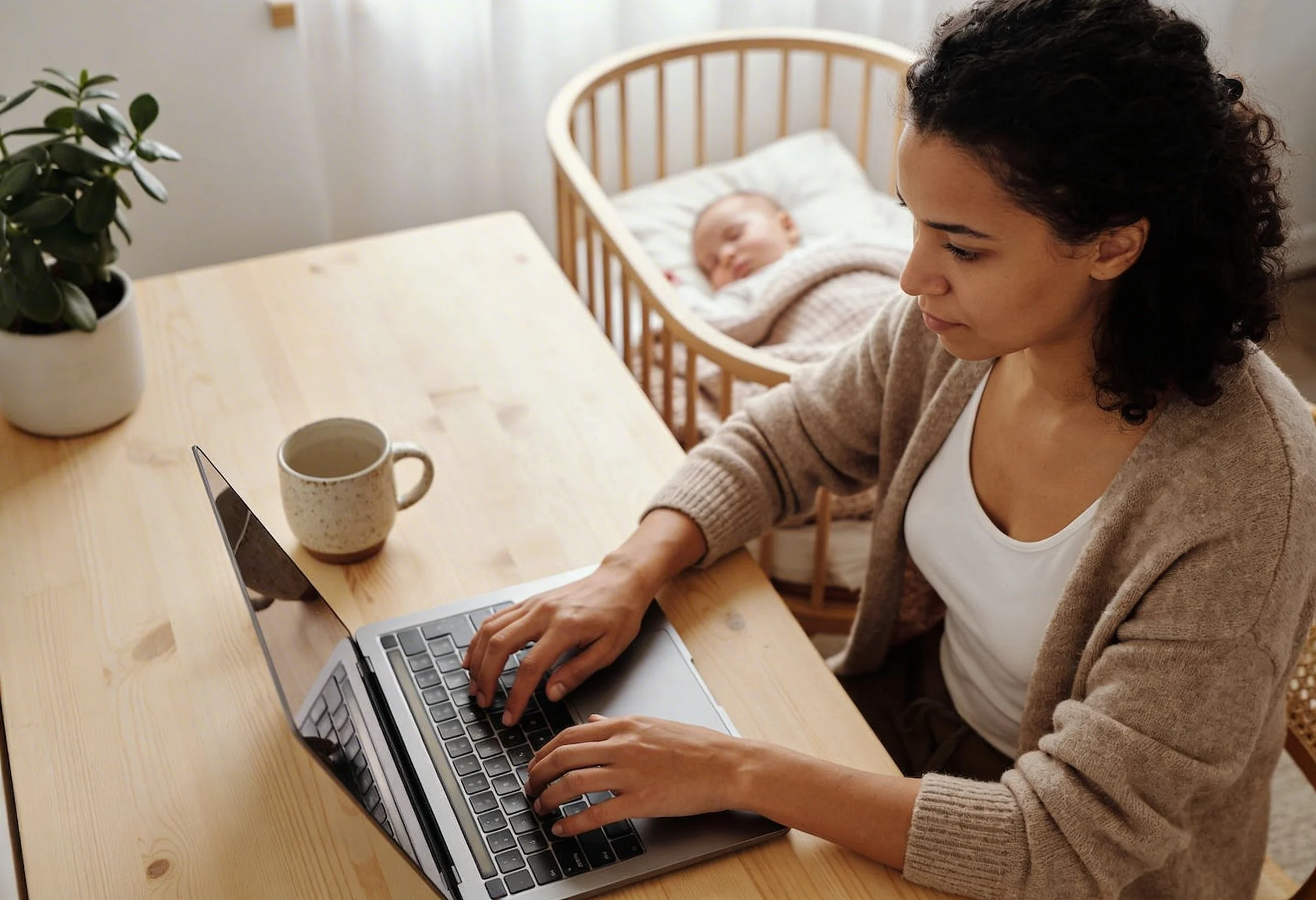 Postpartum mom working with her baby nearby — postpartum nutrition support