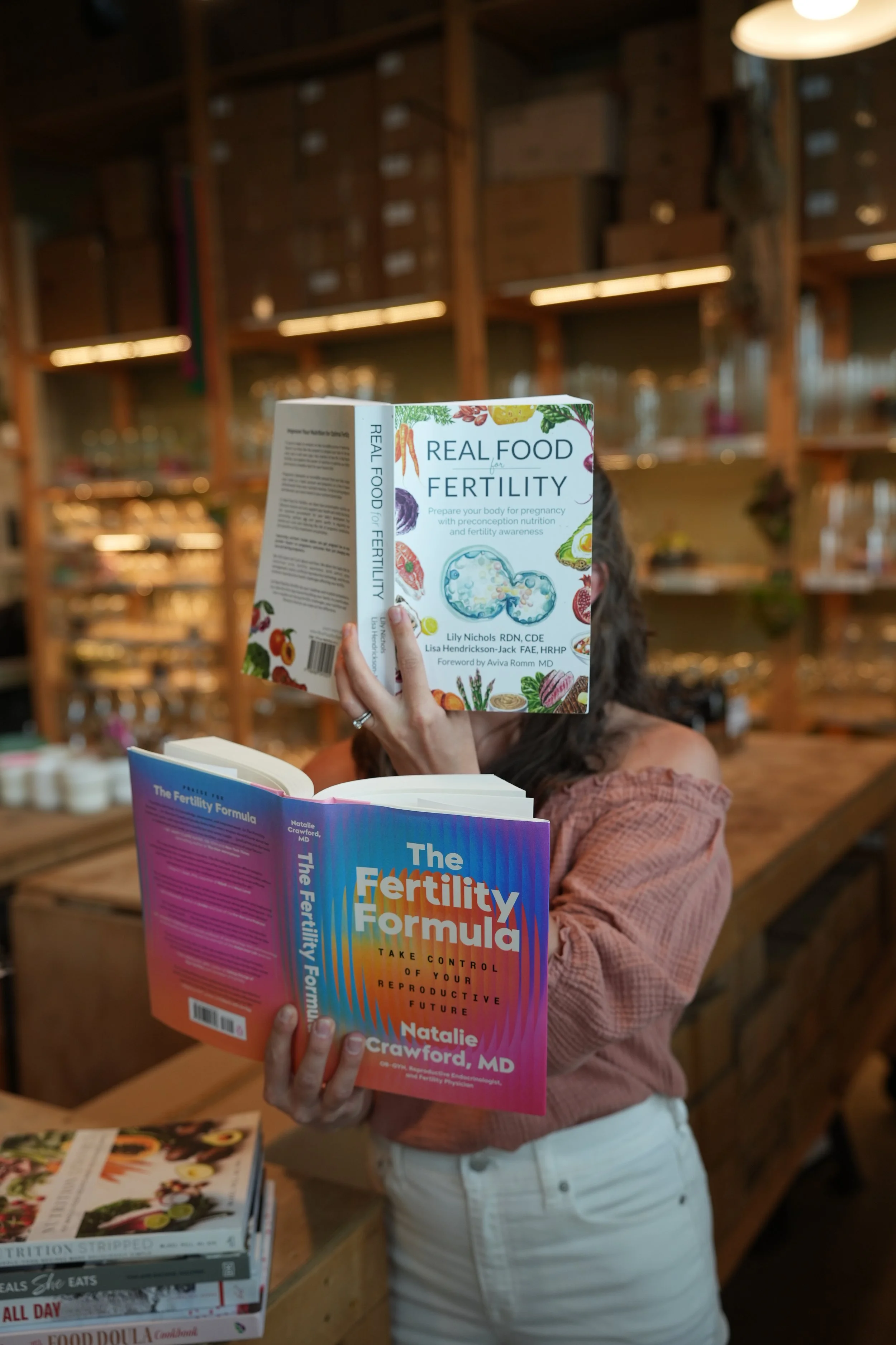 Holding fertility nutrition books 'Real Food for Fertility' and 'The Fertility Formula