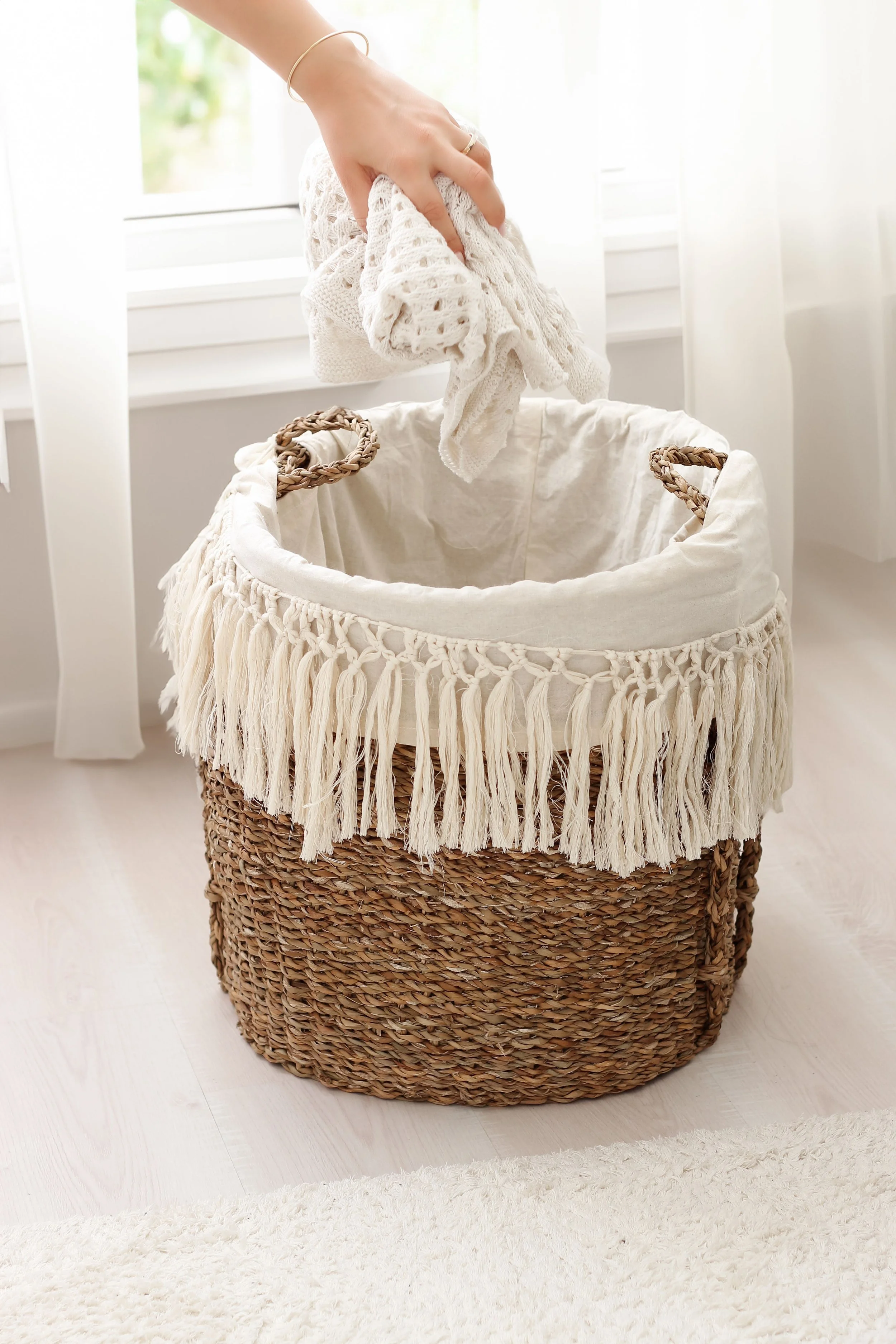 Folding a soft blanket into a basket — cozy postpartum home