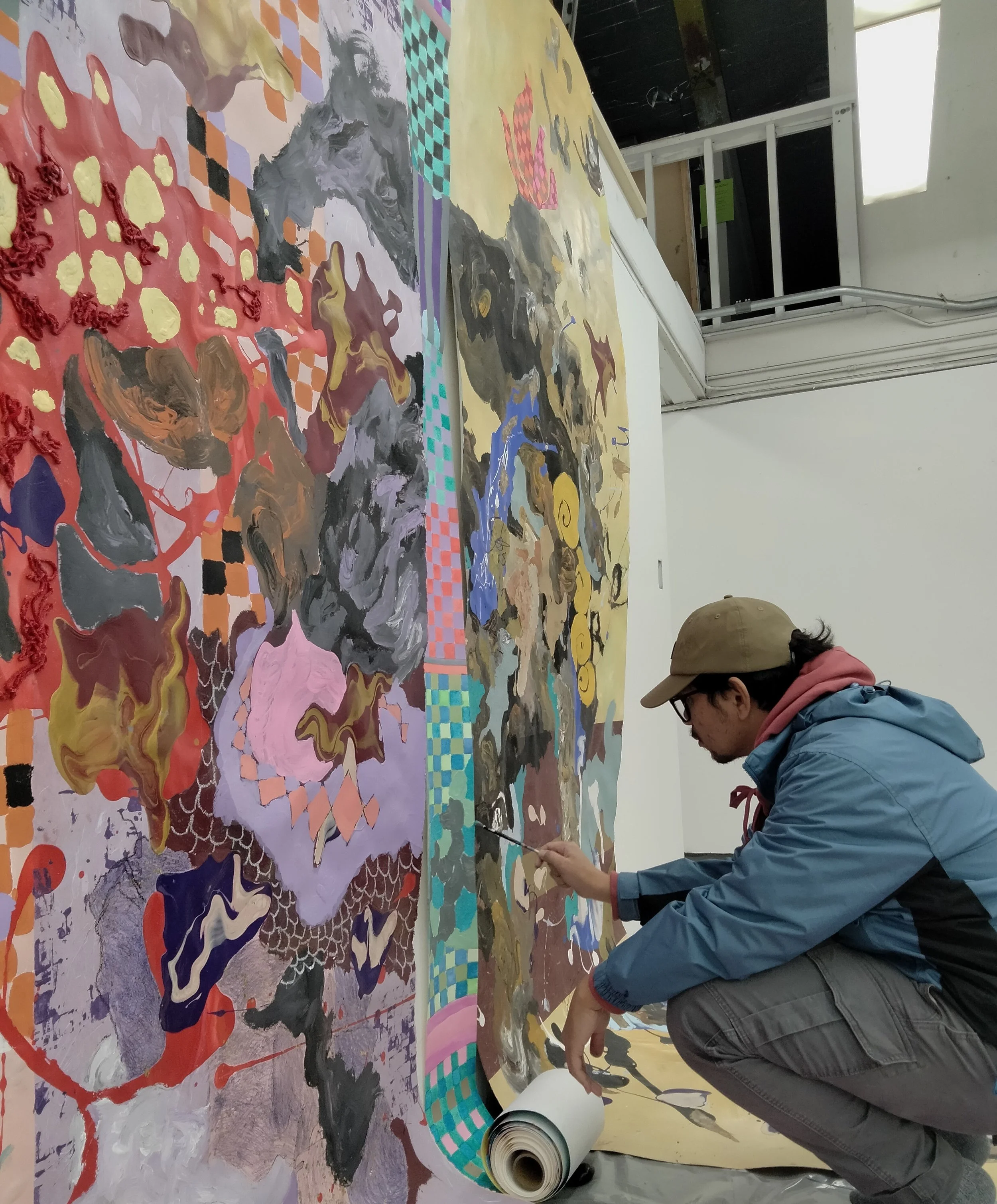 Sokthea working in studio on his large installation painting.