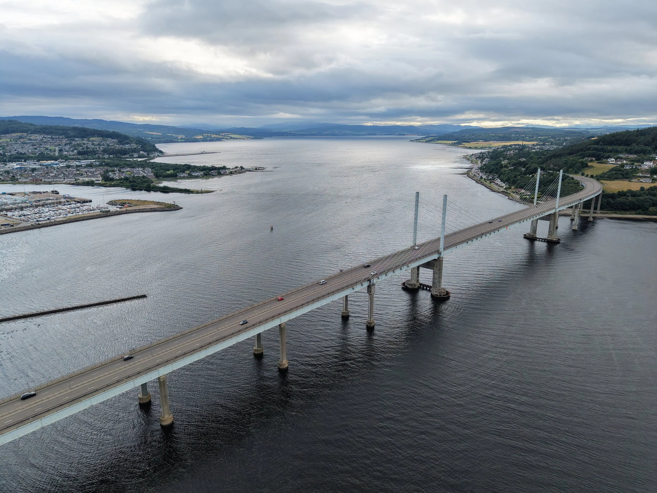 Captured from an elevated perspective, this striking aerial shot highlights the engineering marvel of the Kessock Bridge as it gracefully connects the Black Isle to Inverness across the waters of the Beauly Firth.