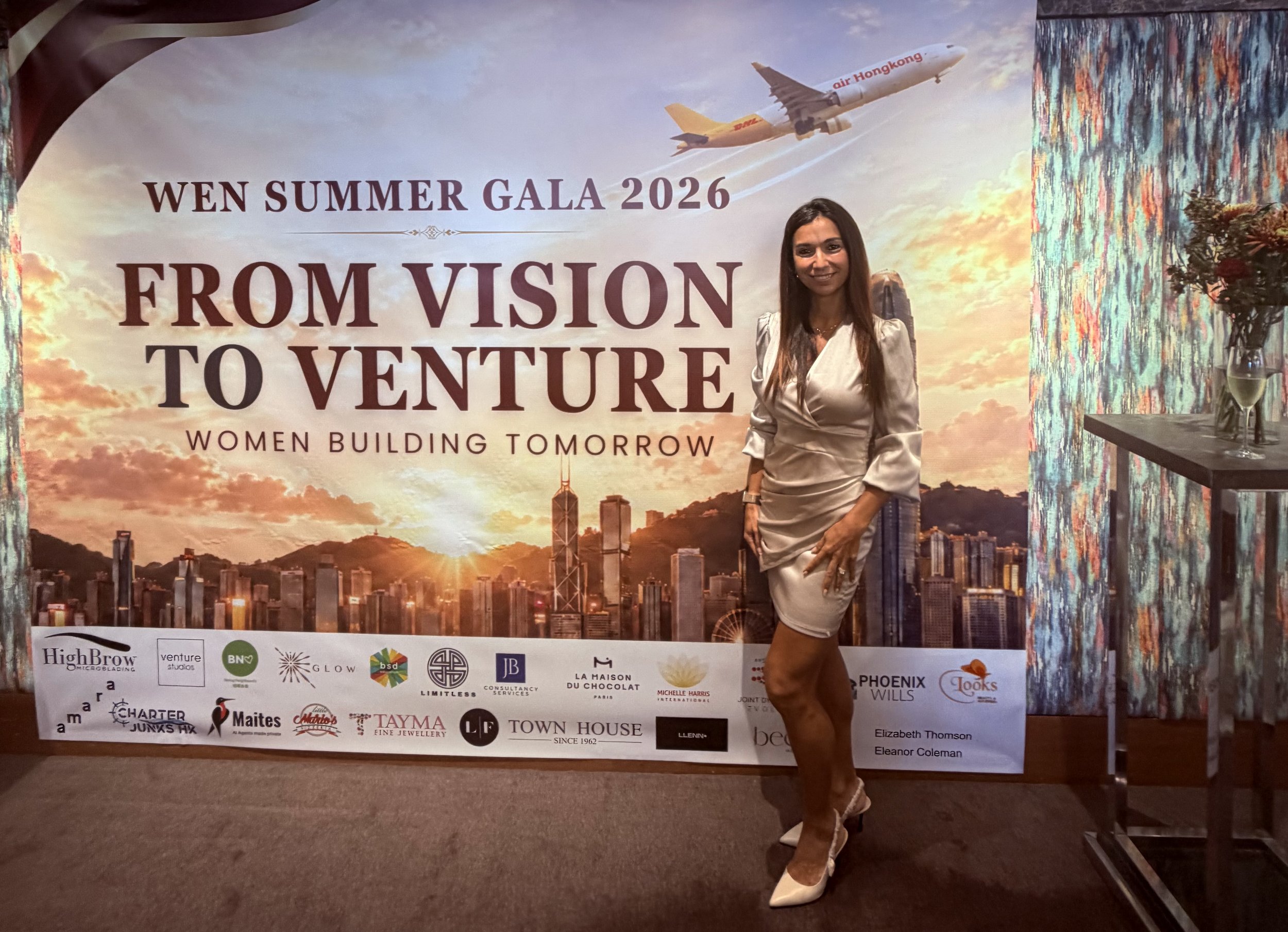 Woman with a silver dress in front of a signage from WEN