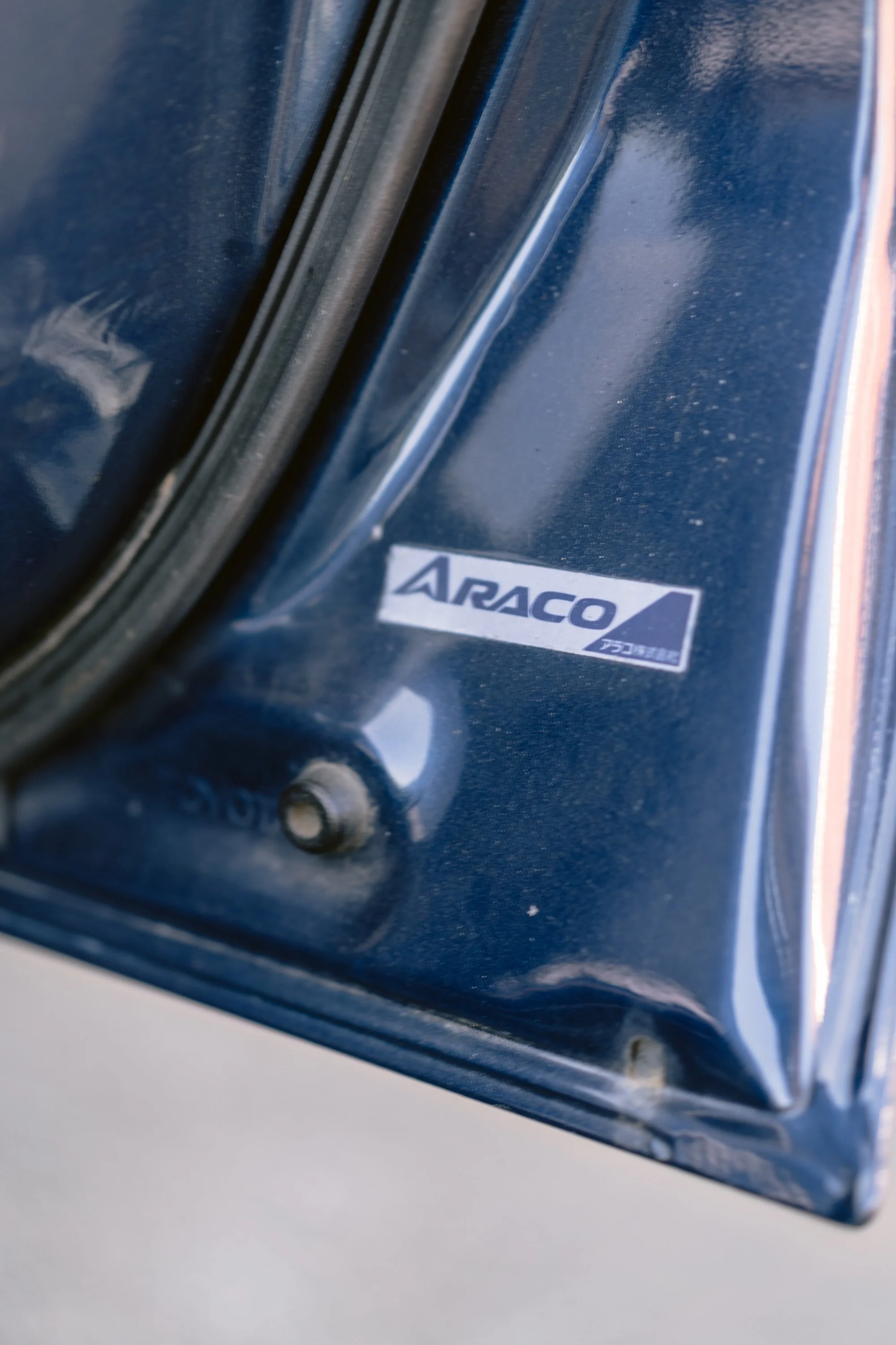 Close-up of a metallic blue ARACO brand appliance with a reflective surface and a partially visible logo.