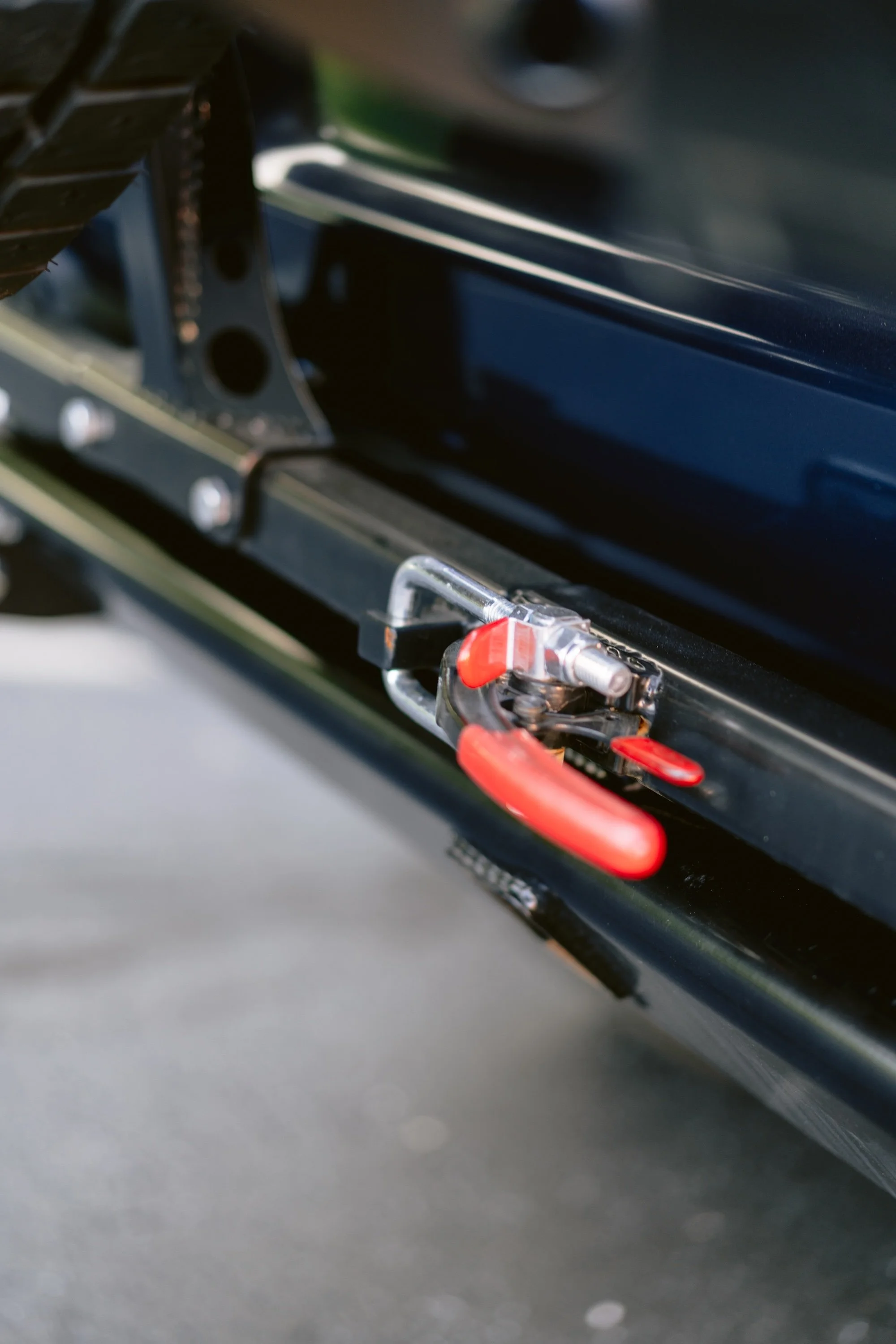 Close-up of a black mechanical device with red handles and metallic components.