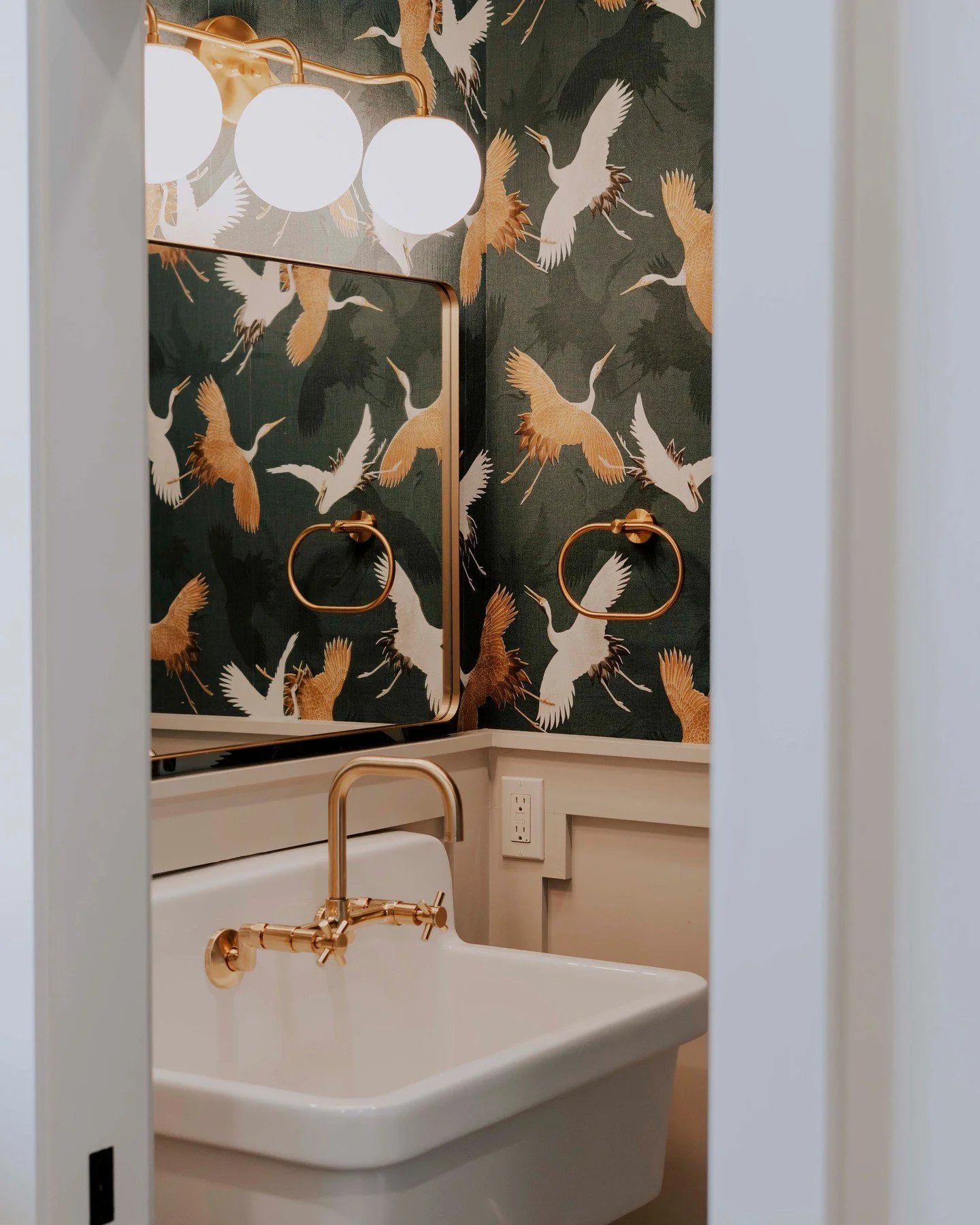 Proof that the powder room deserves a moment. ✨⁠
⁠
Dramatic crane wallpaper, an apron sink, wall-mount brass faucet, and wainscoting that grounds the whole thing. Small space. Zero shortcuts.⁠
⁠
This is what happens when every room in a custom home g