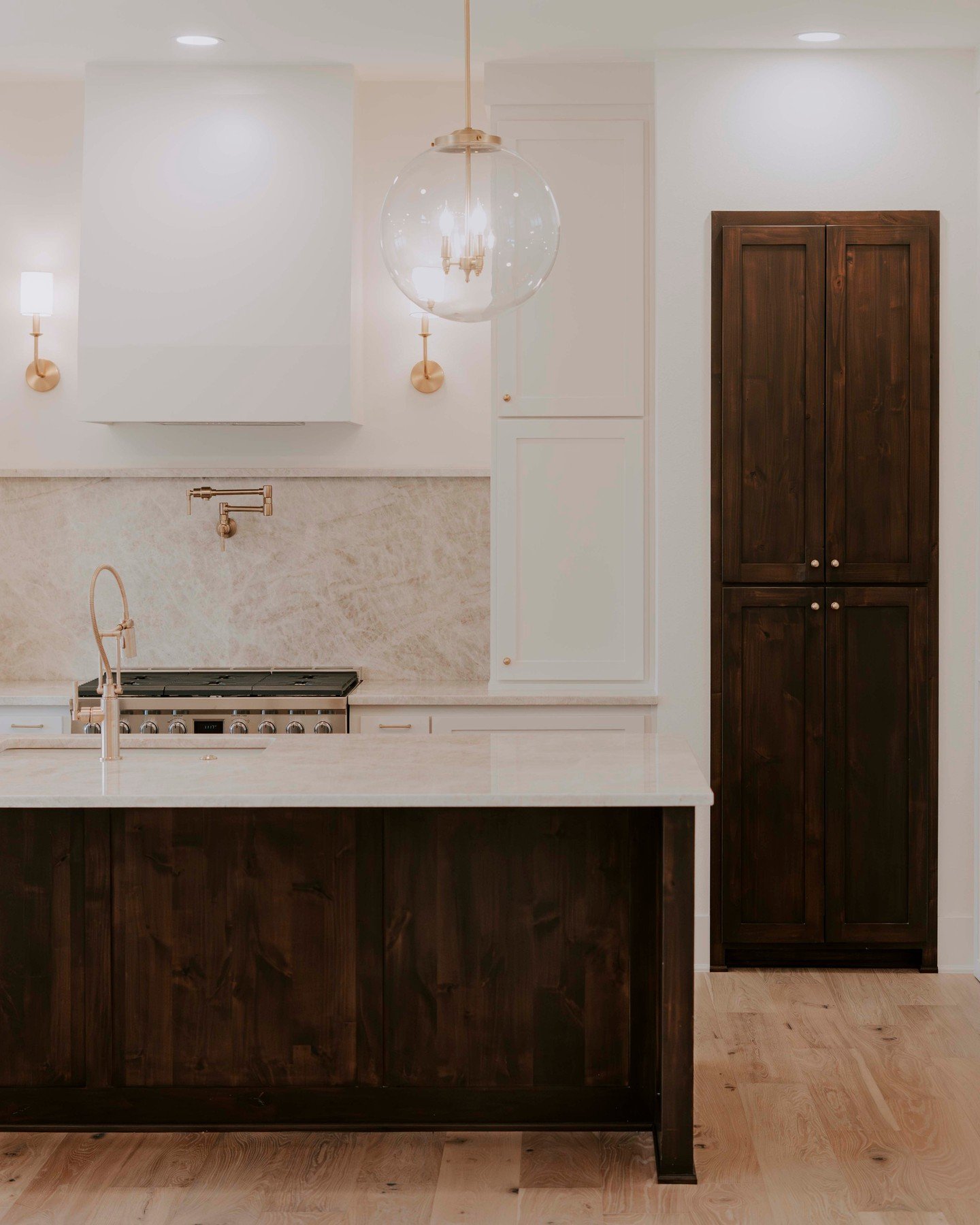 Where warmth meets white. ⁠
⁠
Dark walnut cabinetry. Unlacquered brass hardware. A marble slab backsplash that does all the talking. Every detail in this kitchen was chosen with intention &mdash; and built to last a lifetime.⁠
⁠
This is what happens 