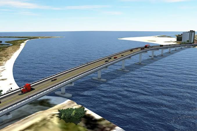Big San Carlos Pass Bridge extending over a body of water with vehicles traveling on it, connecting Fort Myers Beach to Lovers Key state park and sandy shores.