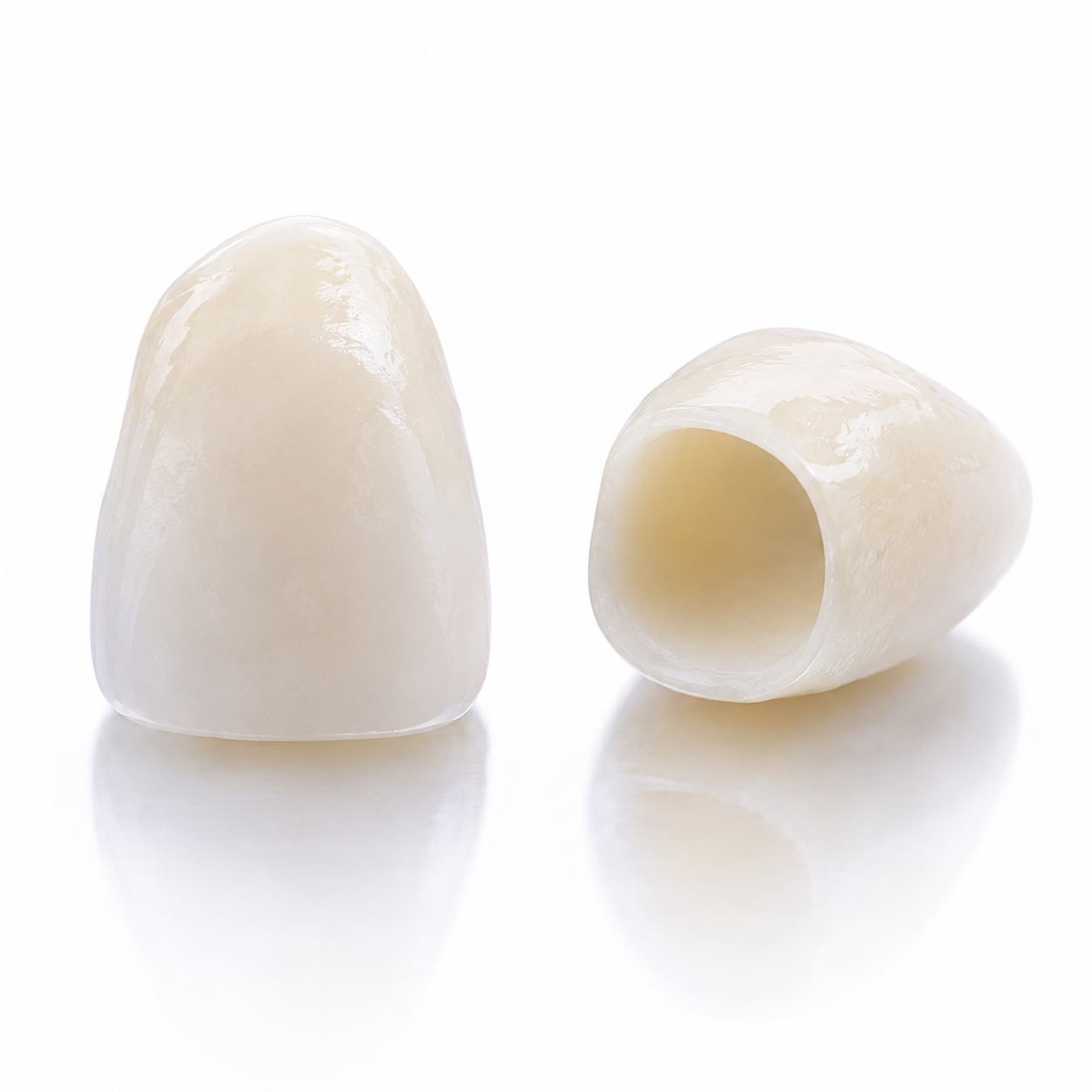 Close-up of two crowns with one standing upright and the other lying on its side, against a white background.