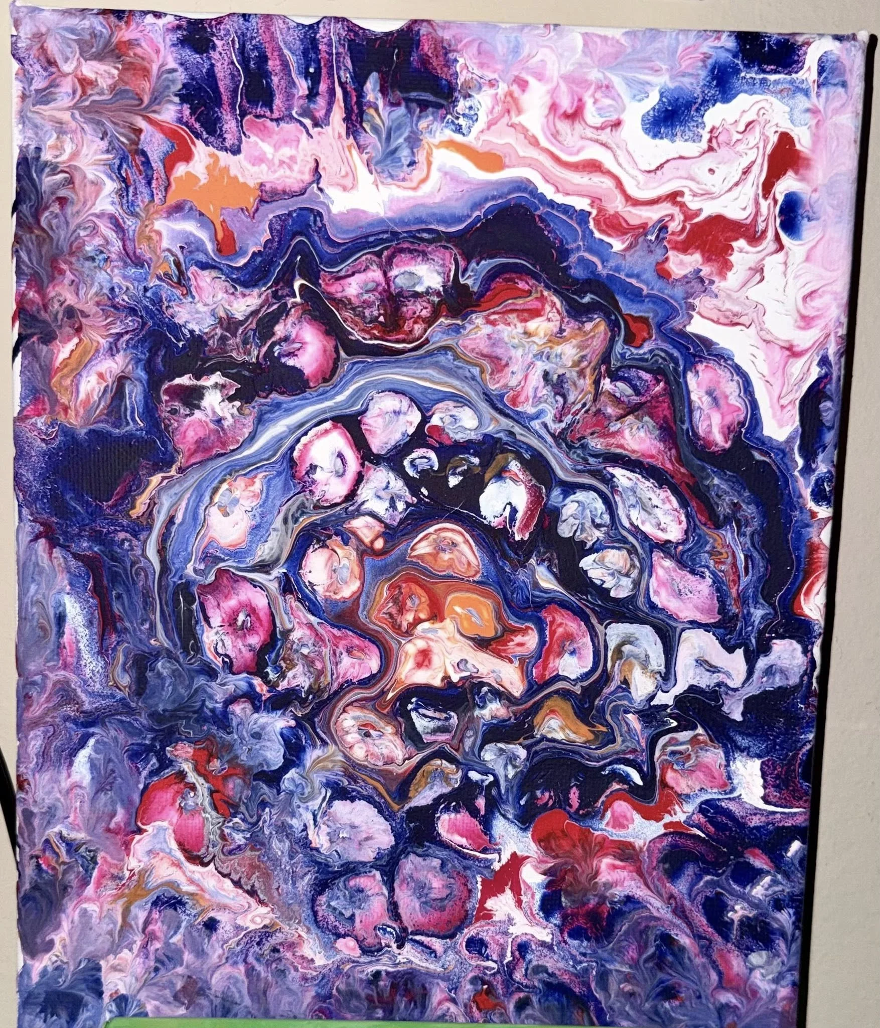 An abstract painting with swirling patterns in shades of pink, purple, red, black, white, gold, and blue, creating a vibrant and dynamic composition.