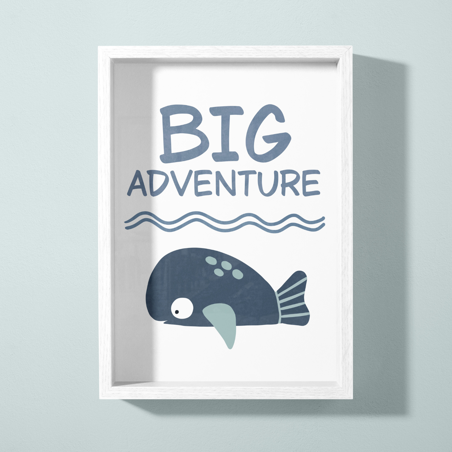 A framed poster with the text 'Big Adventure' and a cartoon whale illustration on a white background wall.