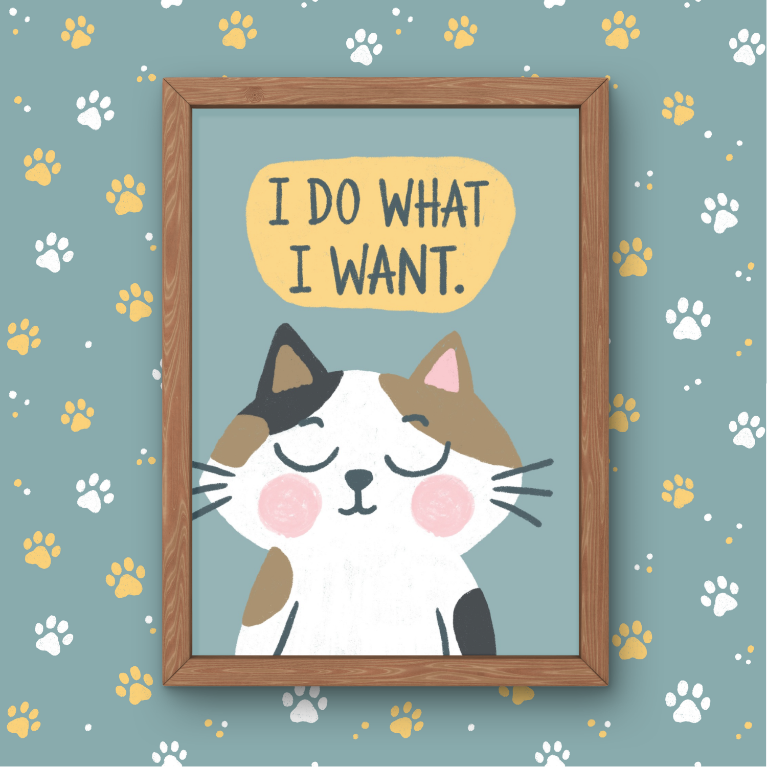 A framed illustration of a cute, smiling cat with pink cheeks and closed eyes, with a speech bubble above it that says "I DO WHAT I WANT." The background is blue with scattered yellow and white paw prints.