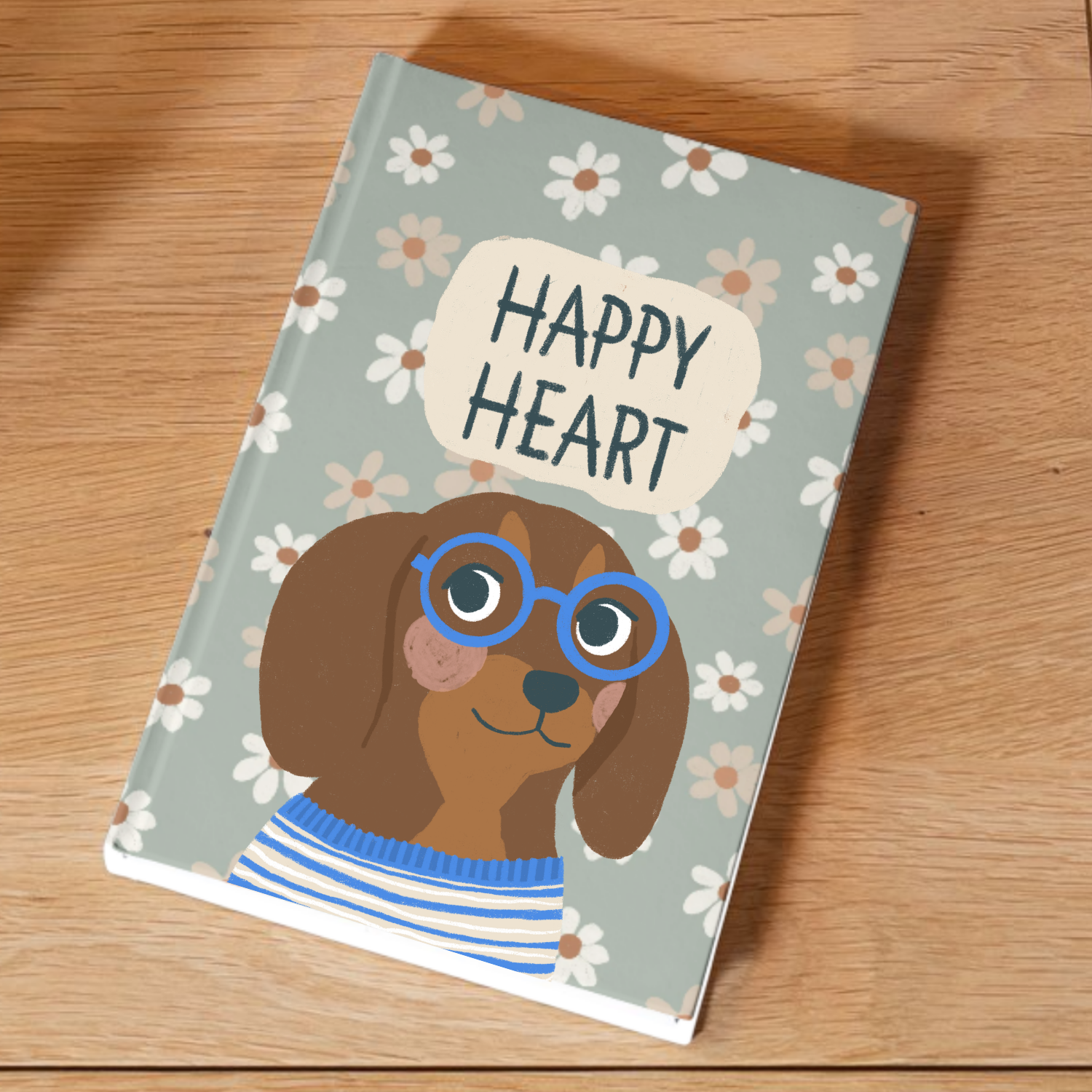 A book titled 'Happy Heart' with an illustration of a dog wearing glasses, a striped shirt, and a floral background, placed on a wooden surface.