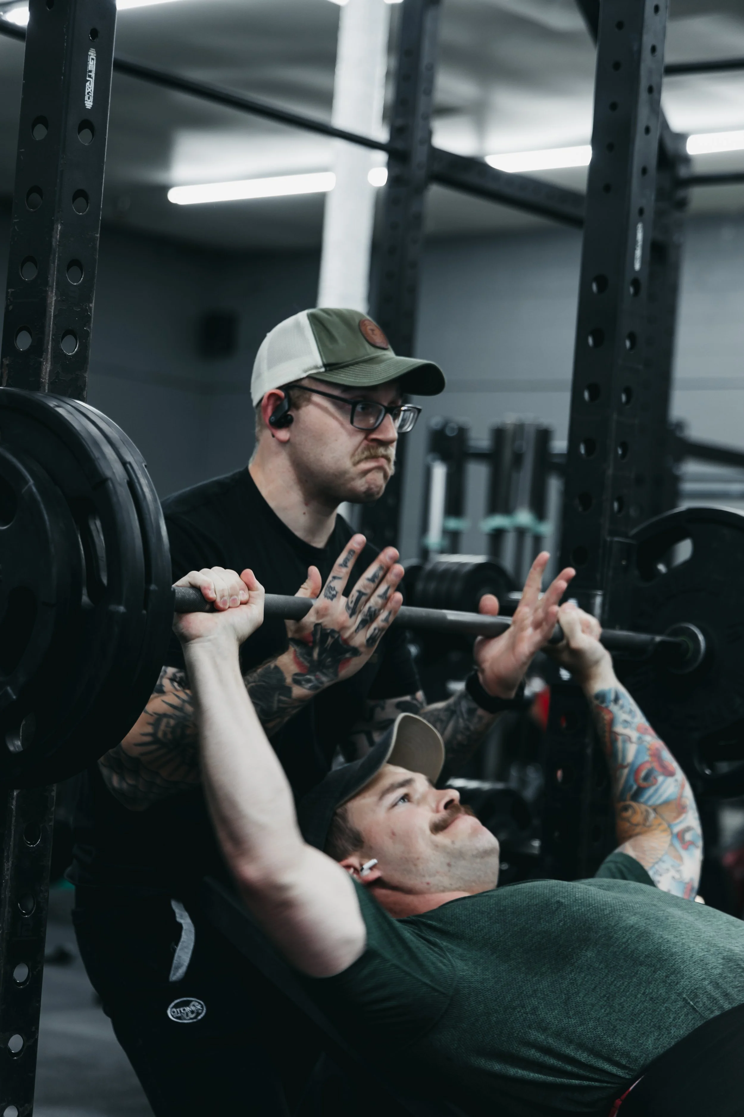 A man bench pressing with another man spotting him.