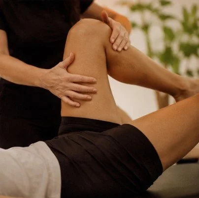 A person receiving physical therapy or massage on their thigh or hip area.
