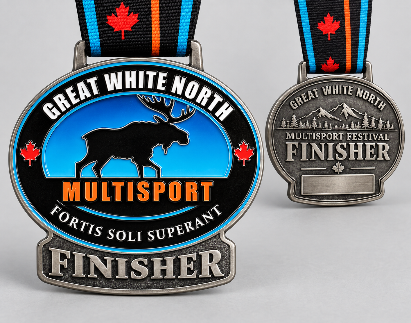 Two marathon finisher medals for the Great White North Multisport Festival, featuring a moose silhouette, Canadian maple leaf symbols, and mountain scenery on the medals, with striped ribbons decorated with Canadian maple leaves.