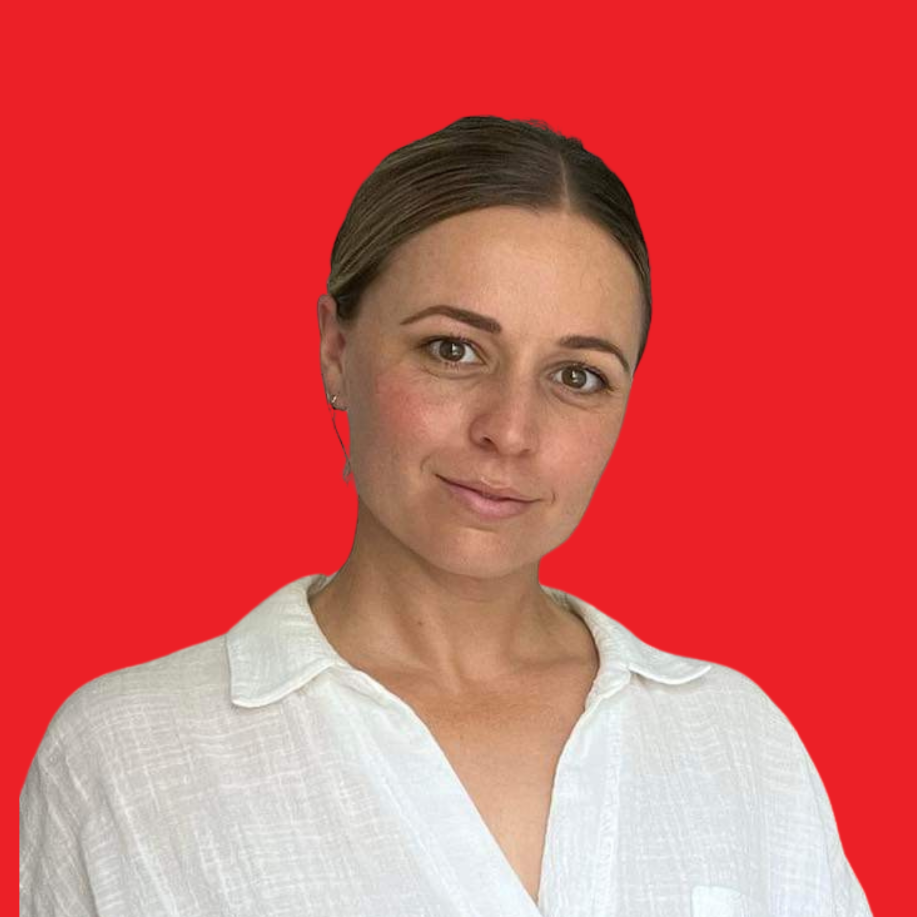 Close-up image of a woman with brown hair, smiling, wearing a white shirt, with a plain red background.