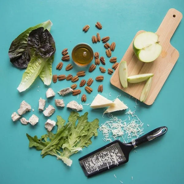 Fresh ingredients for a vibrant salad displayed on a blue surface, showcasing Verde's commitment to wholesome dining in Charleston, SC.