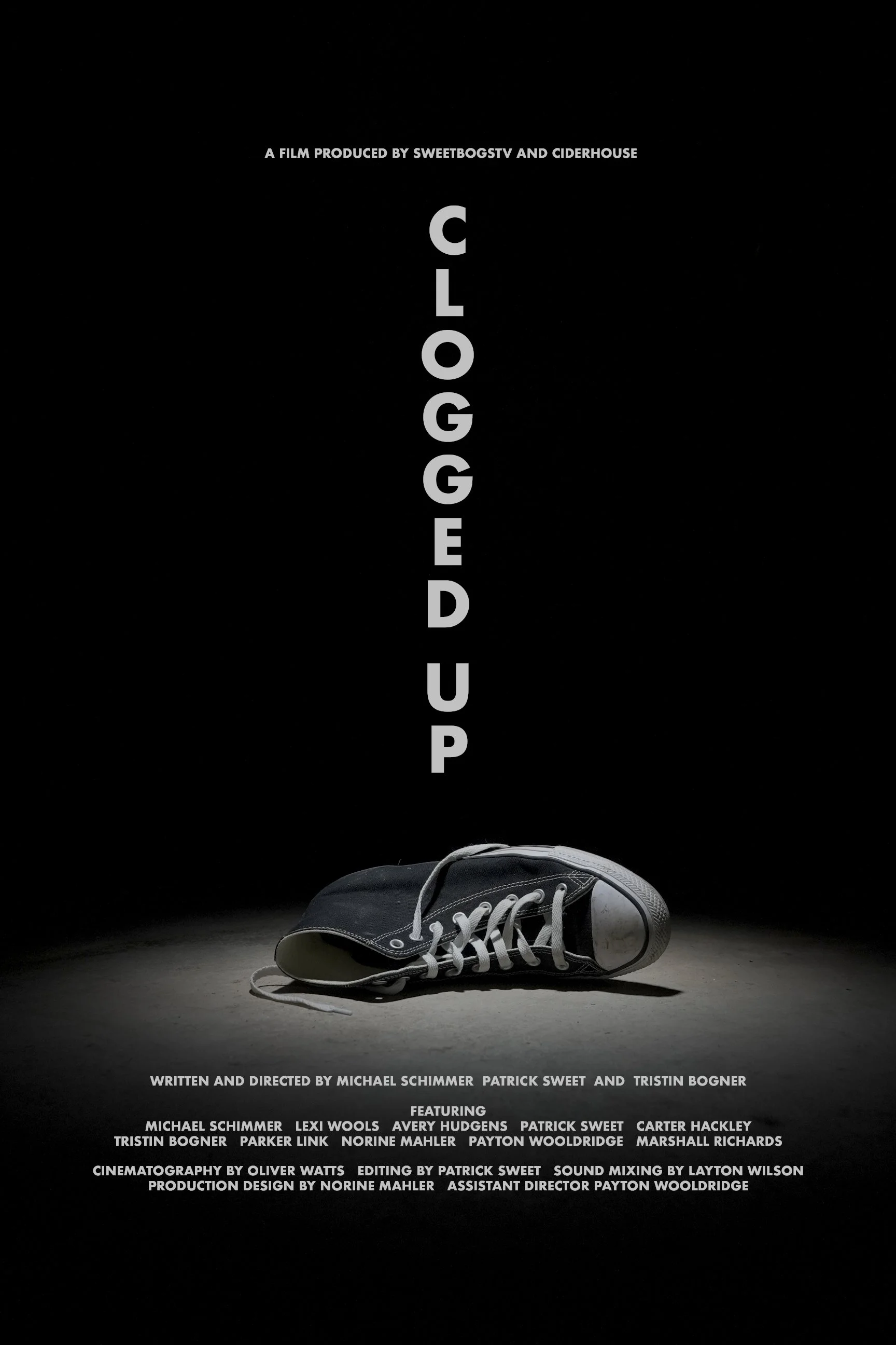 A black background with a single worn black sneaker on the ground and the word "CLOGGED UP" in large gray letters displayed vertically in the center.