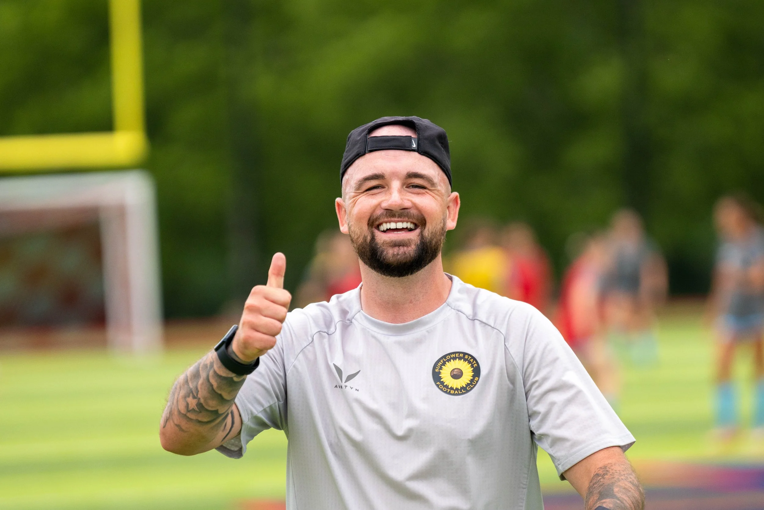 Sunflower State FC coach Alistair Hughes smiles and gives a thumbs up towards the camera during warmups at home vs Oklahoma City FC on June 6th, 2026 - Photo by: Austin Farrow